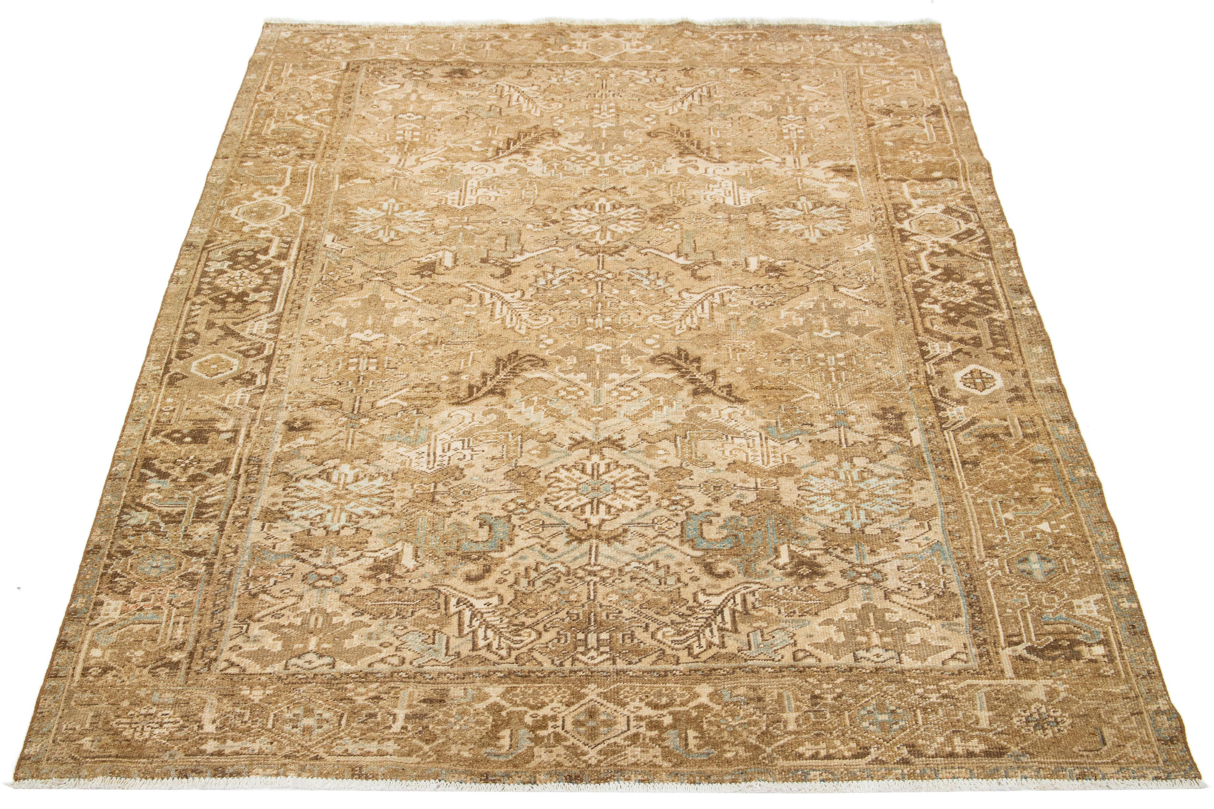 An antique Heriz rug from Persia features a beige field with a blue and brown all-over pattern, hand-knotted using wool.

This rug measures 7'3' x 9'4