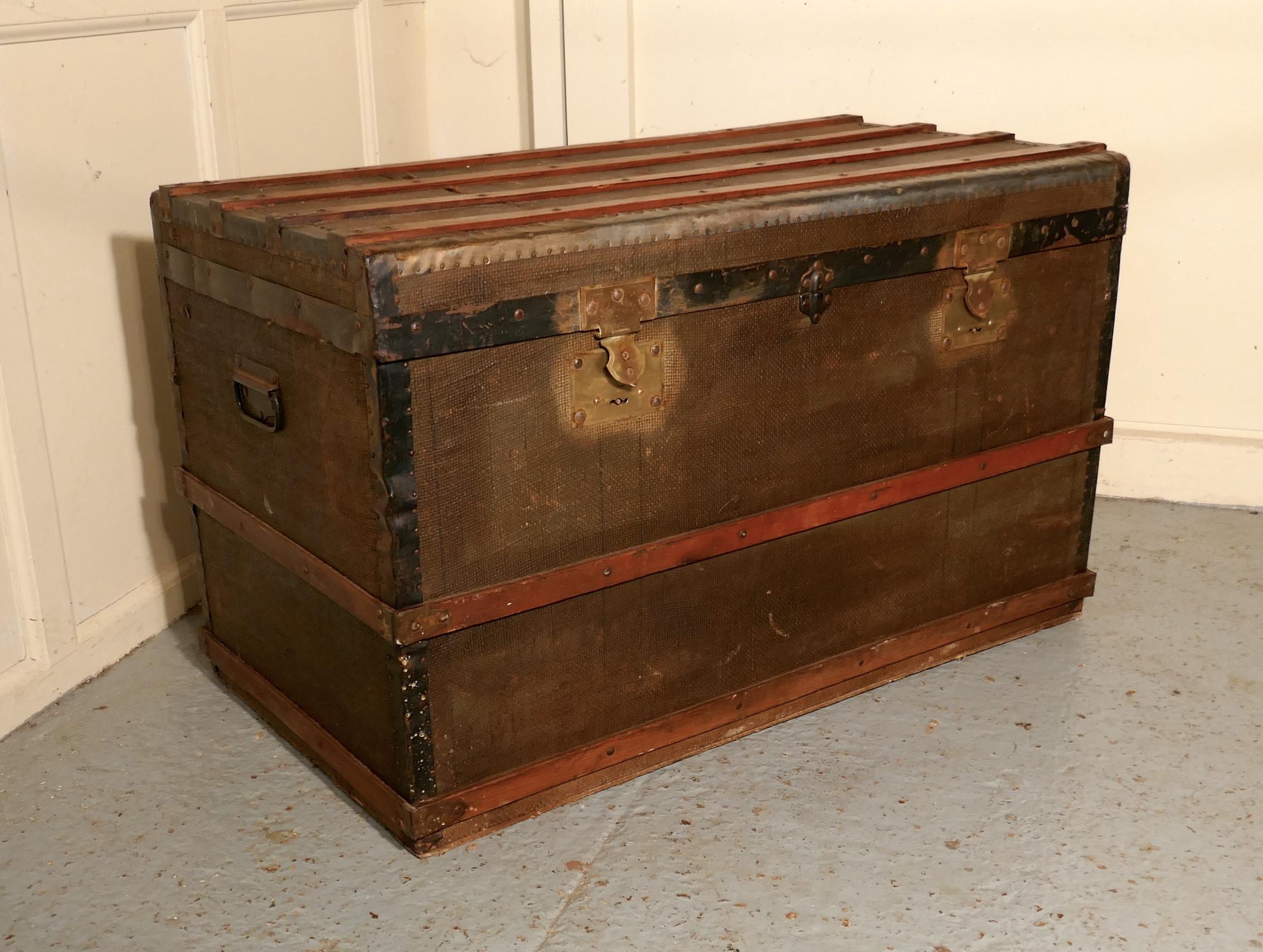 A Vintage Brass and Bound Canvas Travel Steamer Trunk

A very useful decorative suitcase or travel trunk, it is lined in checked paper fabric, it has a fitted section inside with 2 removable trays at the top 
The Trunk is canvas covered, it has wood
