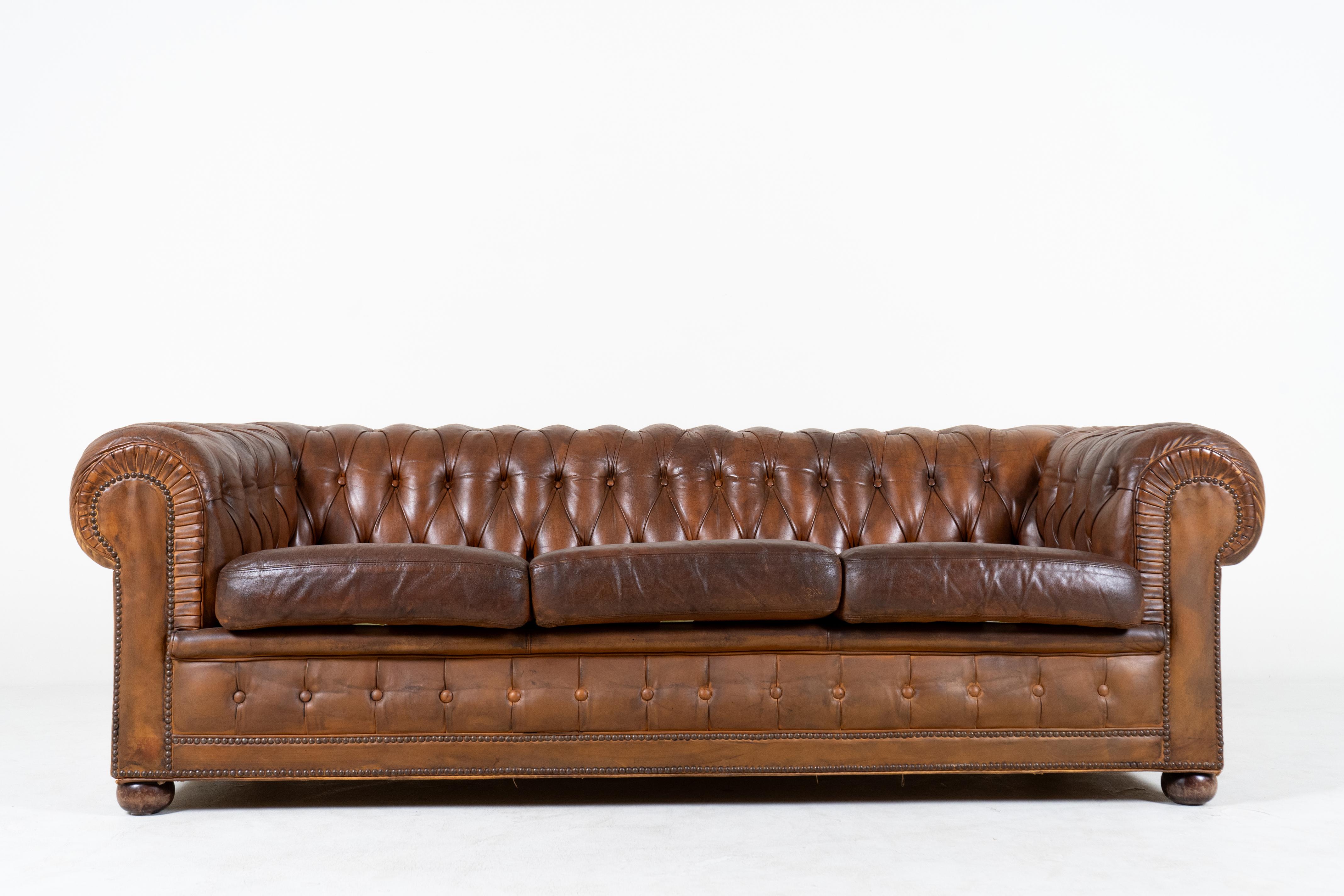 We are delighted to offer this stunning original circa 1960's, very comfortable, fully coil sprung, hand-dyed saddle brown leather club sofa with Chesterfield tufting and exposed nail heads. A very well made, decorative and extremely comfortable