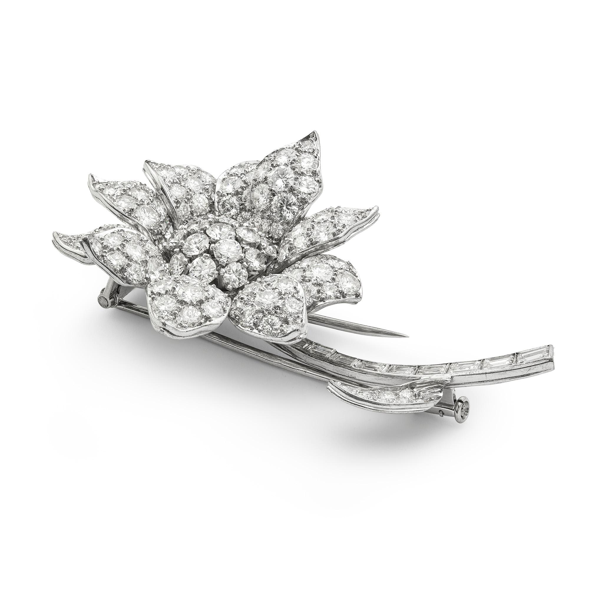 A Vintage diamond-set flower brooch, the centre stamen set as a cluster of round brilliant-cut diamonds surrounded by ten petals set with round brilliant-cut diamonds to a graduated baguette-cut diamonds set stem with diamond-set leaf, estimated