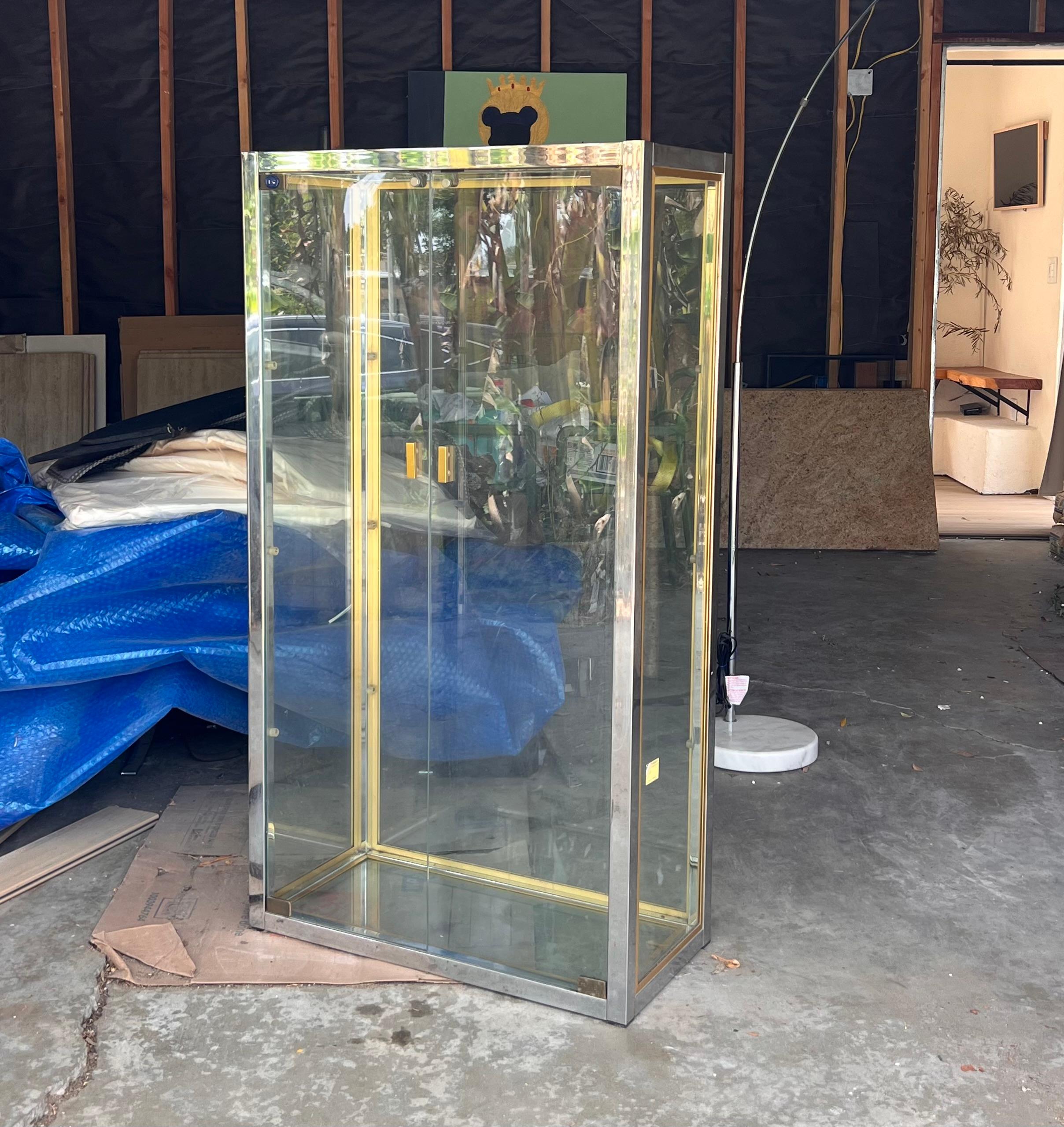 A mid century French glass, brass, and chrome curio cabinet / vitrine by Camard, France 1970s. This stunning piece comes with three glass shelves which are not pictured but in fabulous condition. Note the Camard maker’s mark as well as the wax stamp
