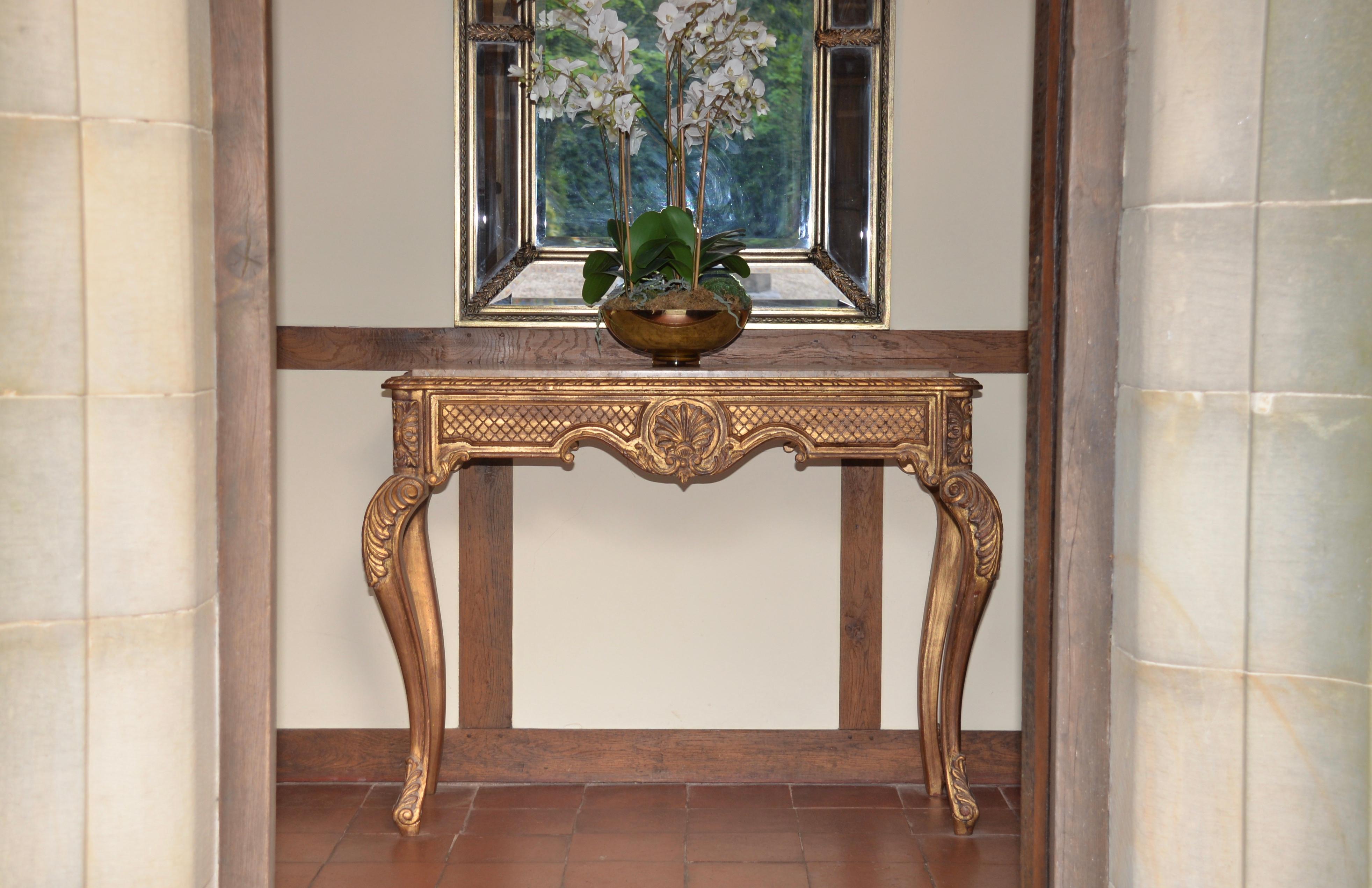 A stunning French vintage gold giltwood and marble top console table. A very striking piece that has beautiful intricate hand carved detail on the wood work. The marble top is genuine solid marble. This item makes for a very striking entrance hall