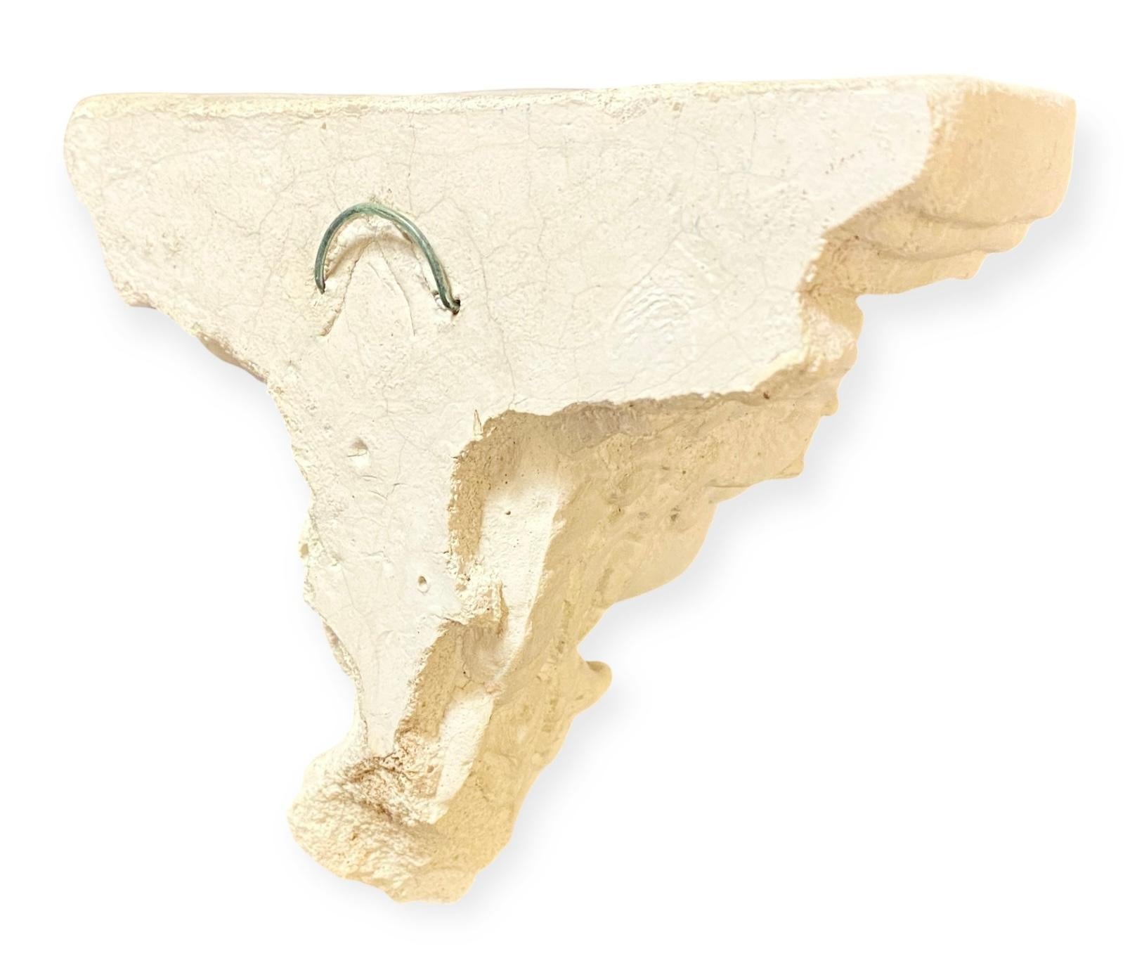 Una piccola mensola da parete in pietra francese vintage degli anni '60 a forma di angelo cherubino con un ripiano sagomato a tre strati in stile neoclassico. 
Il tocco giusto per un piccolo spazio o per una compilazione con un assemblaggio. 