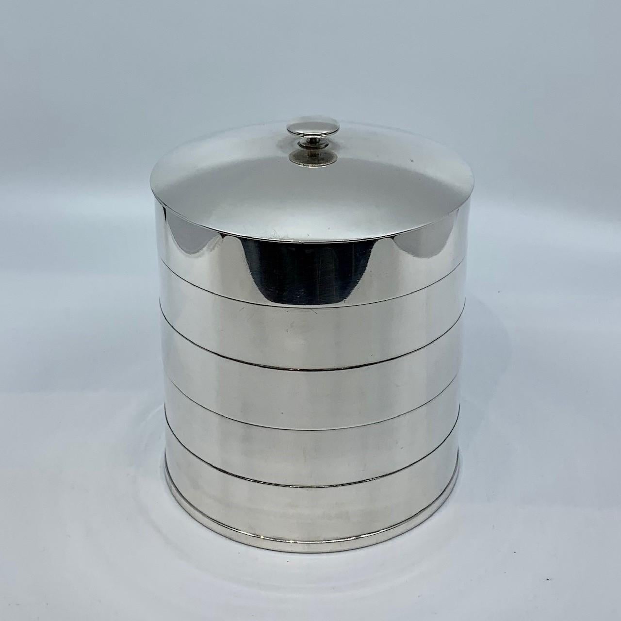 A vintage sterling silver Georg Jensen Art Deco cookie jar, designed by Jorgen Jensen circa 1935. The body is a round cylinder form adorned with four oxidized lines. The top is curved with a simple Deco handle. This piece is perhaps unique, it has