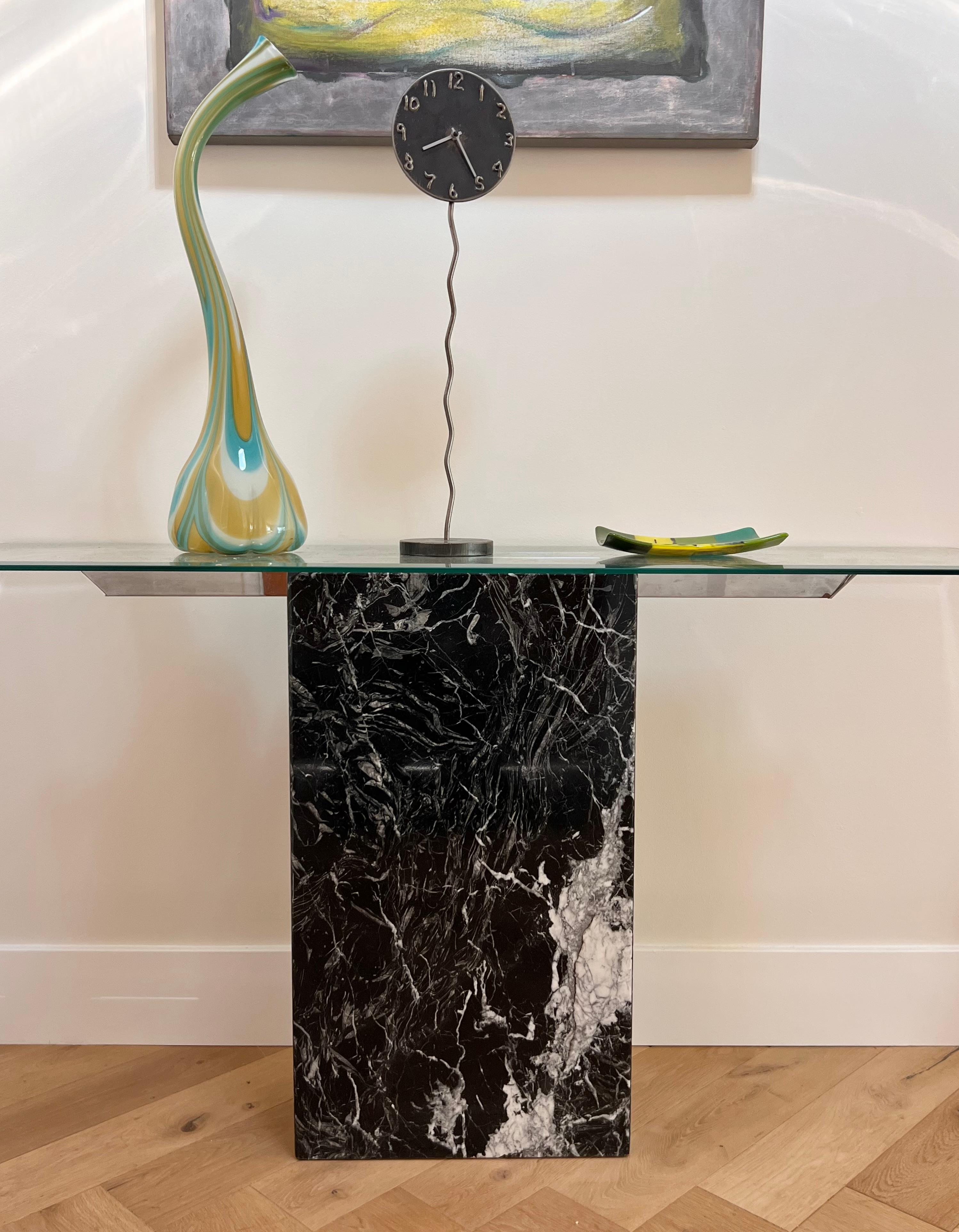 A vintage Italian postmodern black marble console table with chrome inserts which uphold a beveled glass top, circa late 1970s. A sophisticated statement piece that will elevate any interior. Glass can be removed for easier storage and transport.