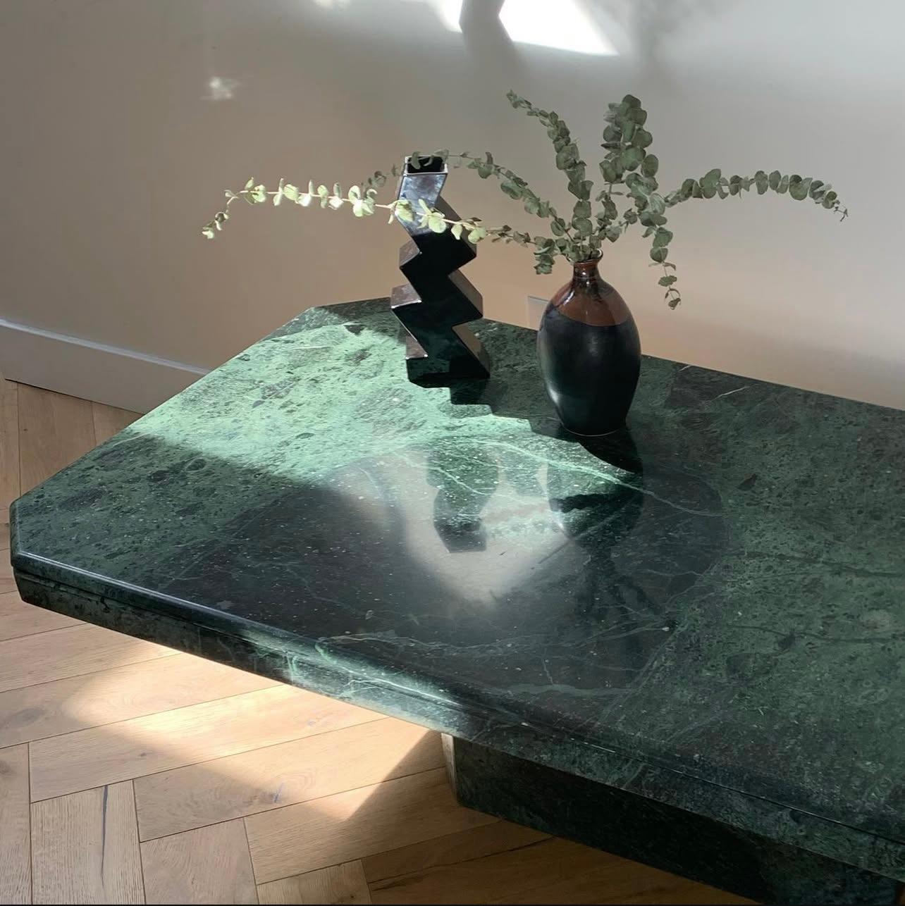 Une table basse postmoderne italienne vintage à piédestal en marbre vert, vers la fin des années 1970 ou le début des années 1980. Dans des tons somptueux d'émeraude avec des veines de pin. Un épais bord en porte-à-faux rend cette table unique, de