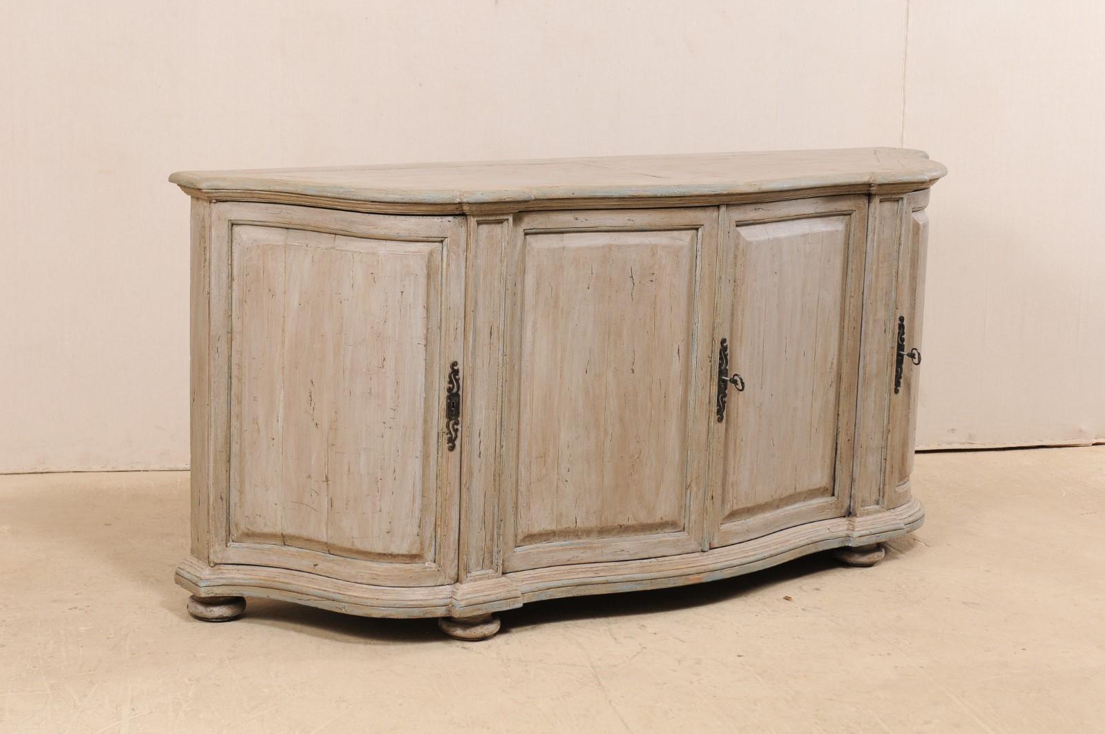 An American made, Italian design inspired, console cabinet. This vintage Italian style buffet cabinet features a fluid demi-style top, whose shape is mimicked in the body beneath, and fitted with four doors. The doors each have raised panels and