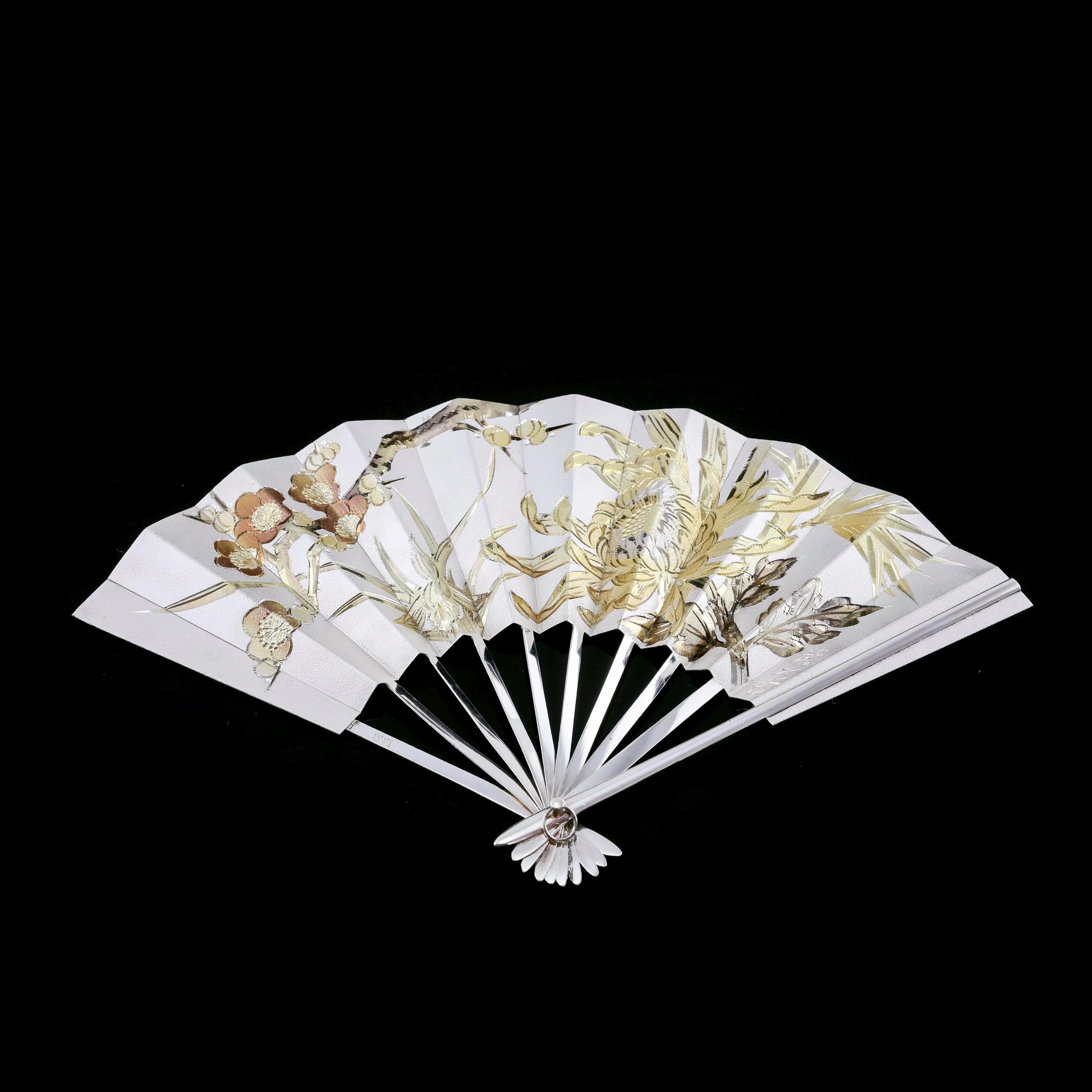 We are delighted to offer this beautiful vintage Japanese solid silver fan/Sensu/O-gi made circa 1960s. 
 
The fan can be displayed on a wooden stand (included) and presents itself with a pronounced contrast of the silver background and the mixed