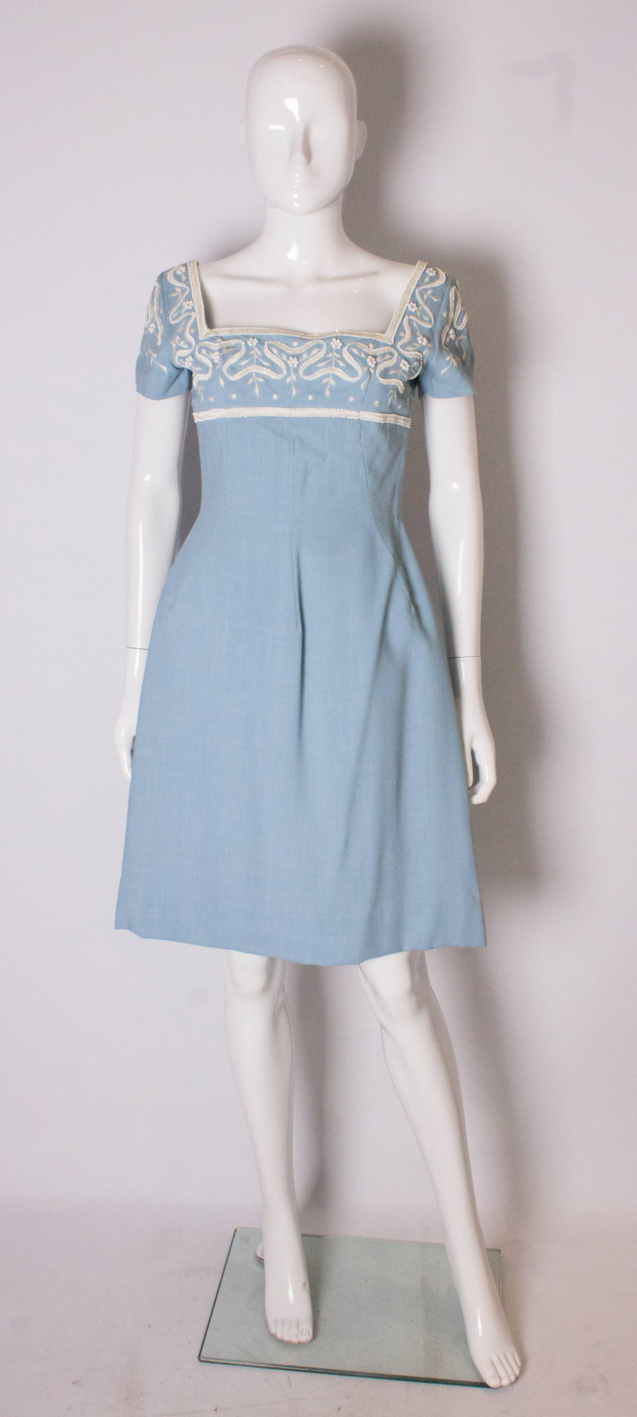 A pretty vintage blue dress by Jean Allen , London. The dress is in a sky blue linen / cotton fabric with white bead embellishment. It is fully lined with a central back zip and a 3'' hem.