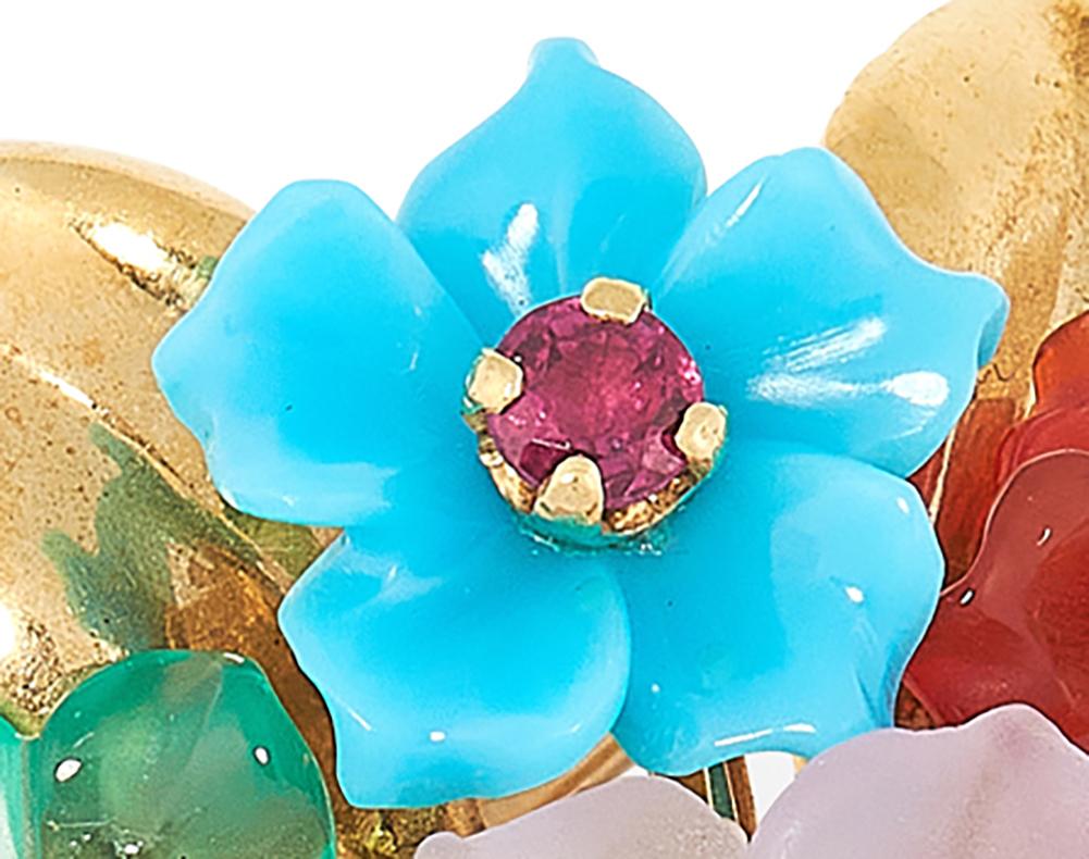 A joyful vintage jewelled brooch, designed as a bouquet of flowers with the petals carved in various gems including turquoise, rock crystal, carnelian, lapis lazuli, coral, etc. The petals are set at the centre with round cut rubies, emeralds,