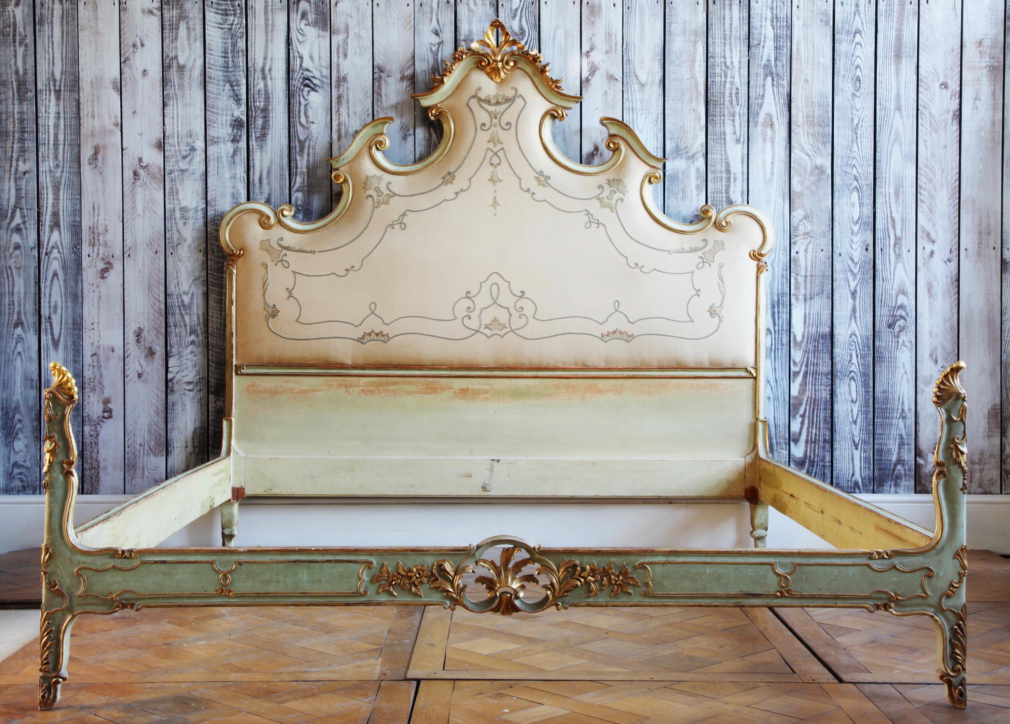 An grand sized Louis XV style  bed hand carved in wood and made in Italy, circa 1940s. The bed’s proportions of a large imposing headboard, designed with the curves and flowing lines of the Rococo style coupled with a low styled footboard make for a