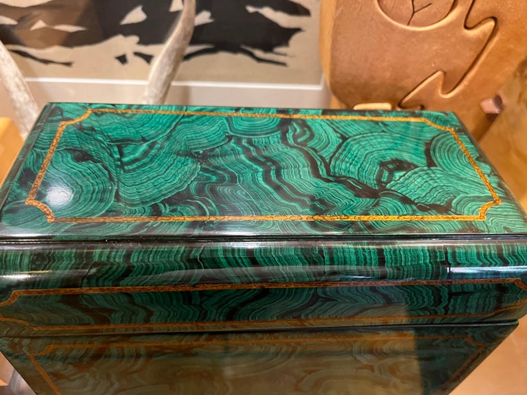 An impressive example of a Maitland Smith faux malachite lidded box with gold lined accents.