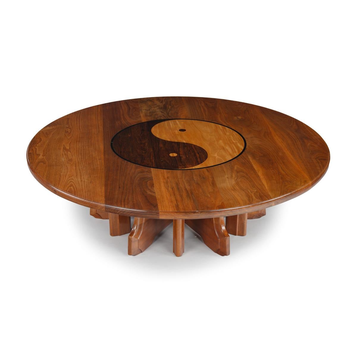 An unusual metamorphic centre table in Walnut satinwood and various exotic timbers. The table reduces to a coffee or low table by splitting in the middle of the base and rotating, allowing the two sections to join together and make a low