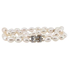 Un bracelet vintage signé Mikimoto en perles à double brin monté sur de l'or 14 carats.