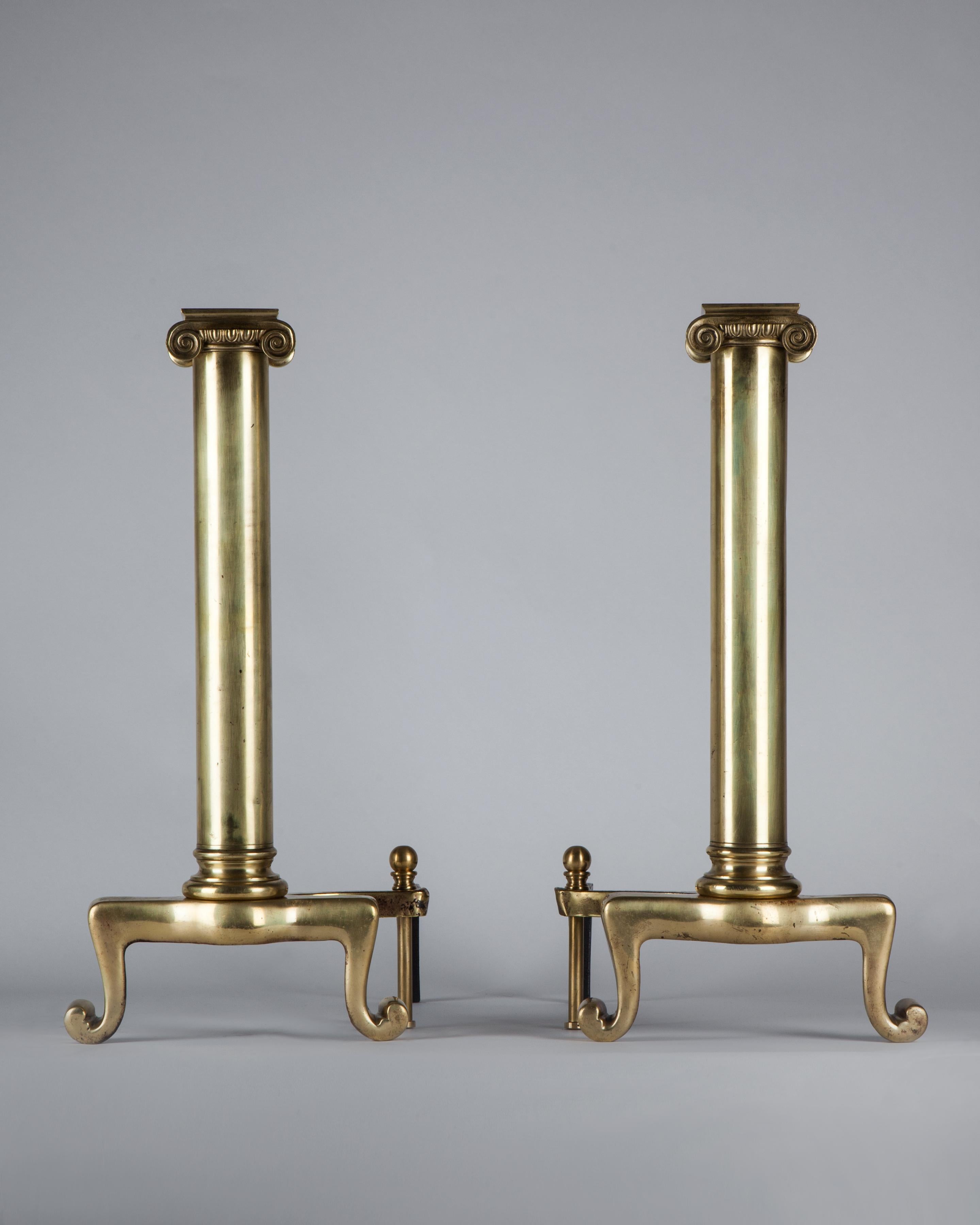 AFP0578
A pair of vintage brass Ionic column andirons with scroll feet in a mellow aged brass finish, circa 1900.

Dimensions:
Overall: 23-3/4