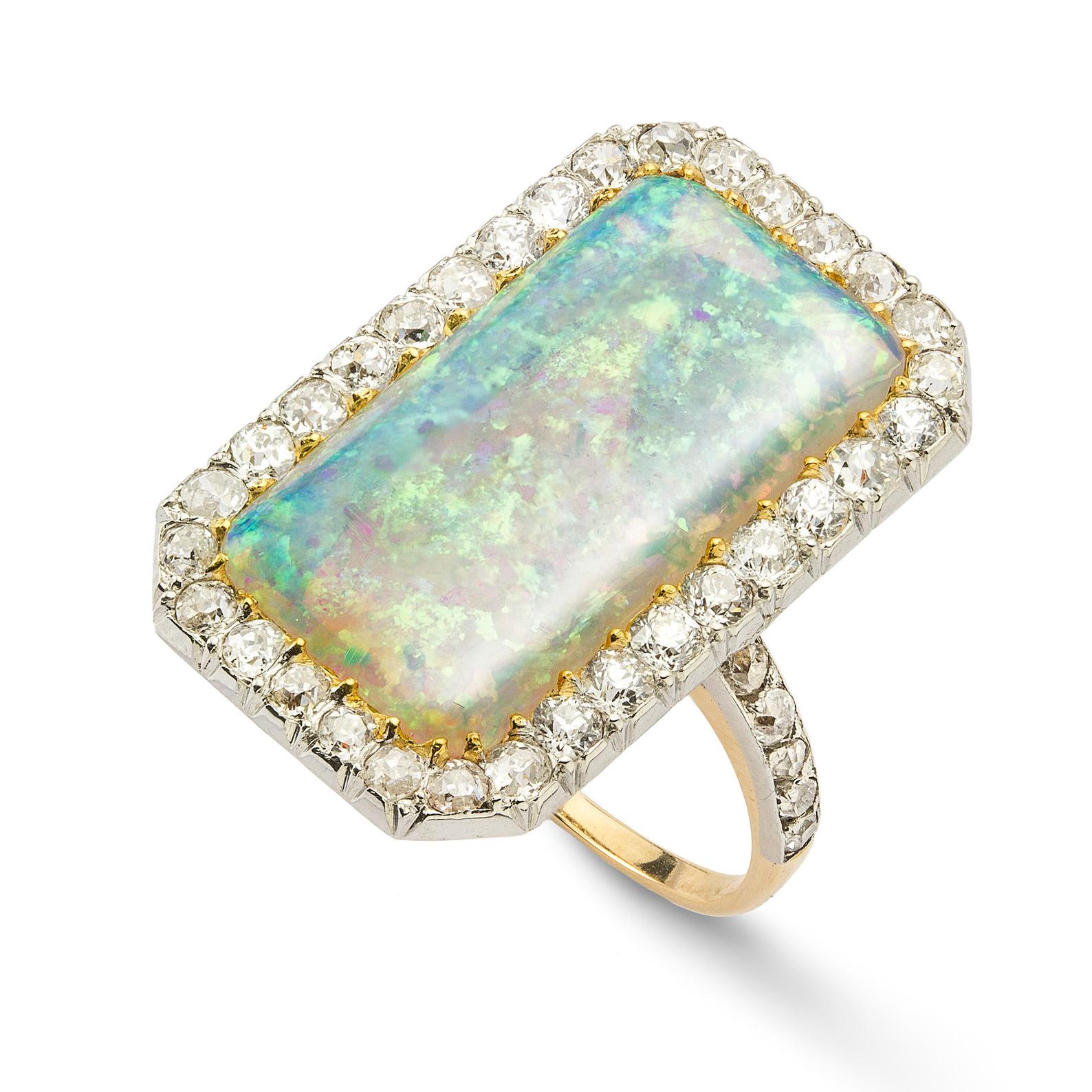 A vintage opal and diamond cluster ring, the rectangular cabochon-cut opal, measuring 19.6 x 10.3mm, claw set to a surround of old brilliant-cut diamonds estimated to weigh a total of 0.8 carats, cut down set in platinum to a gold mount with