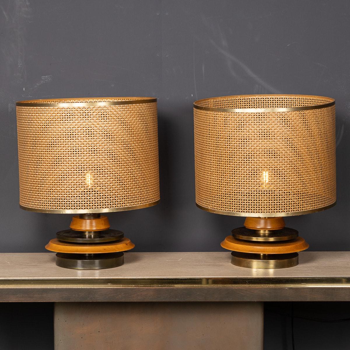 A wonderful mid 20th Century pair of wooden lamps crafted by the esteemed Italian designer, Scarnicci. Adorned with sizable Bergere shades in impeccable condition, their allure is undeniable. Adding refined sophistication to any living space they