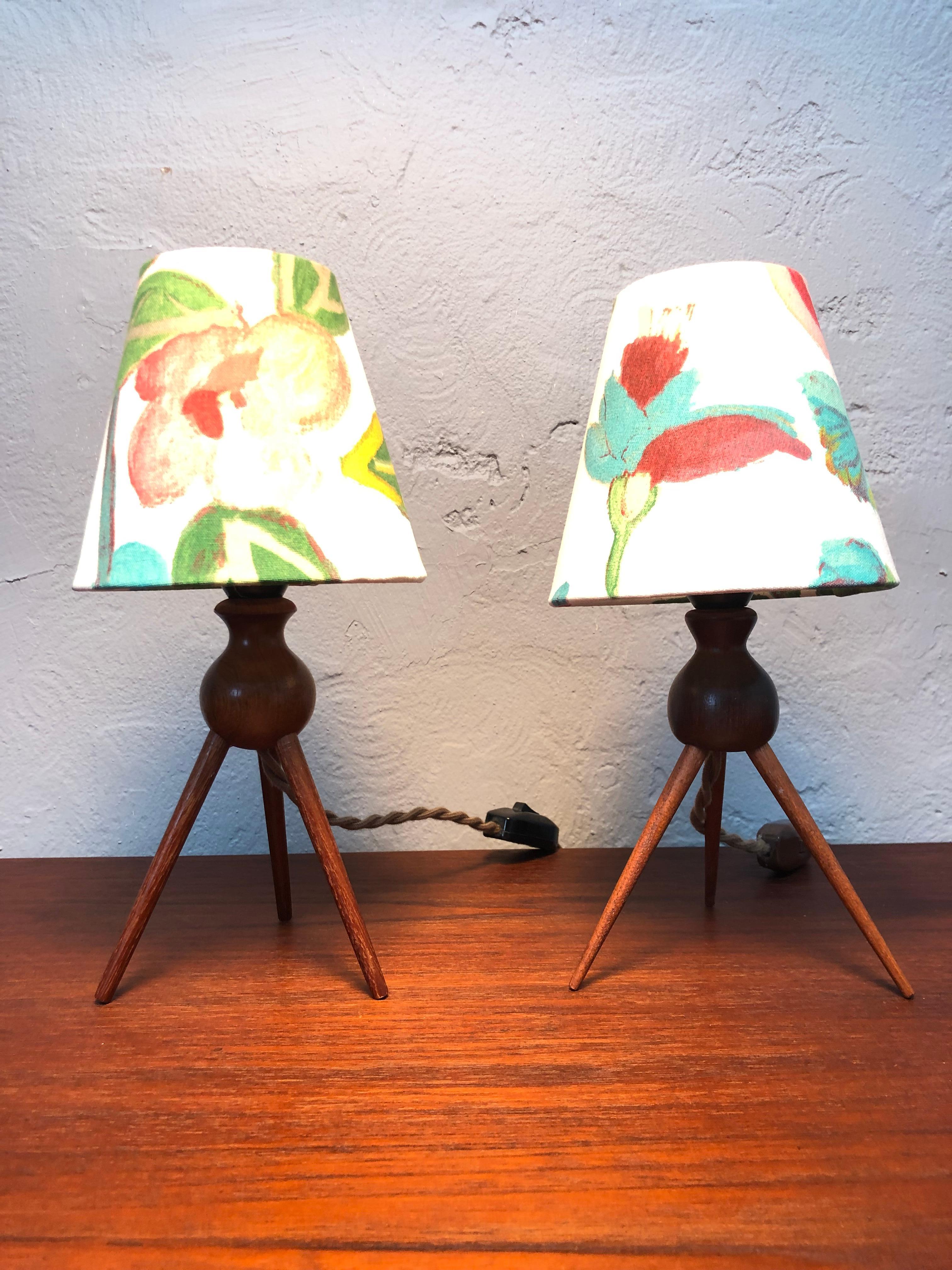 A pair of vintage Danish midcentury teak 3-legged table lamps.
With Gallery Sixty One lamp shades included. 
Solid teak turned legs and body. 
Can be fitted with a US or EU plug.
Great as bedside table lamps. 