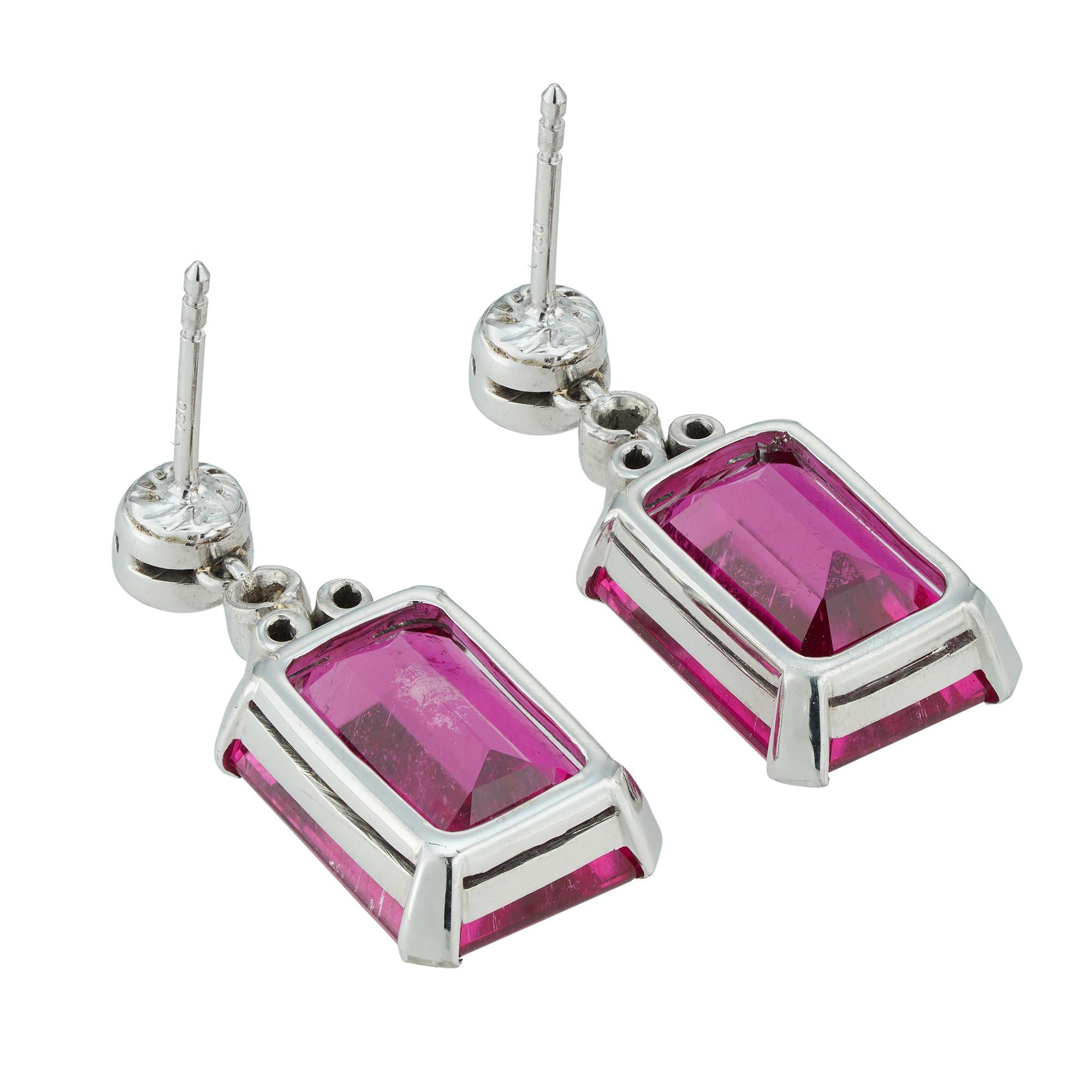 A vintage pair of rubellite and diamond drop earrings, each earring set with an octagonal-cut rubellite, the one weighing 6.90 carats and the other 6.95 carats, each with three small old-cut diamonds set on the top, all suspended by a larger old-cut