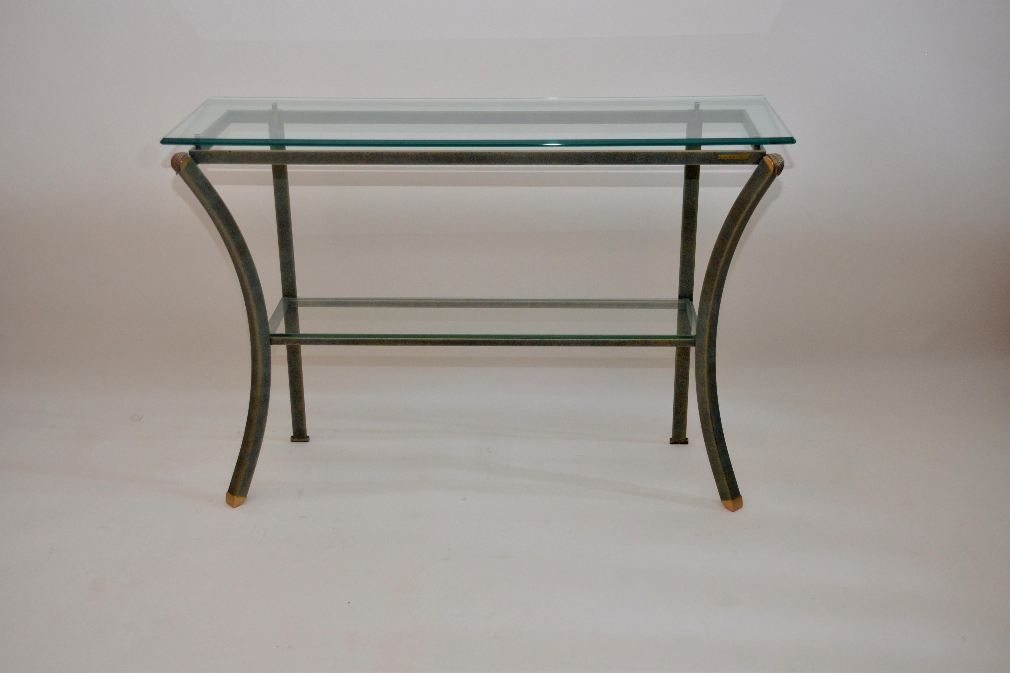 Vintage Pierre Vandel console table in a green and gold finish. This item has brass feet and a pretty brass leaf design on each of the top corner castings. An original beveled glass top with a shelf below. A unique Classic 1970s Pierre Vandel design