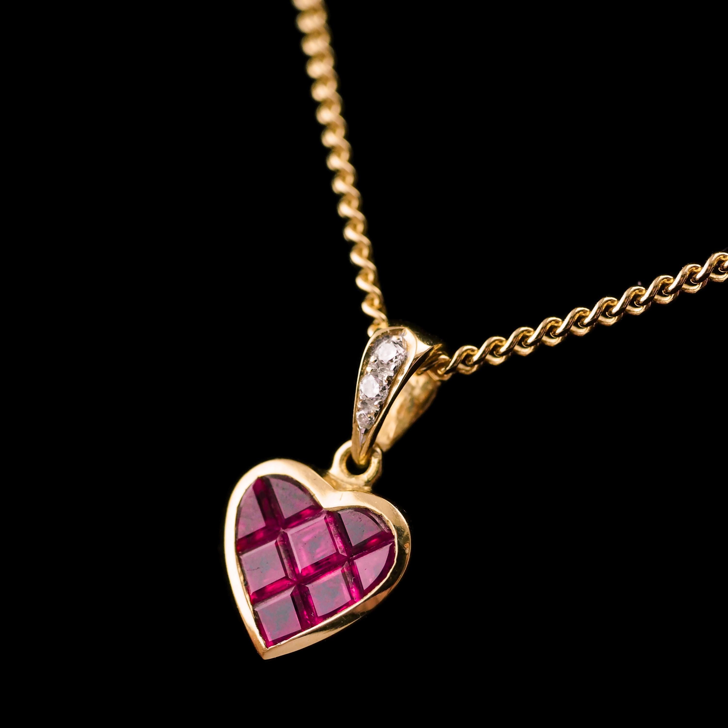 We are delighted to offer this lovely Vintage 18K gold ruby necklace (chain is included and is also 18K solid gold). 
 
The pendant features a latticework design with 8 finely set rubies all faceted and forming a heart shape. The 'ball' of the