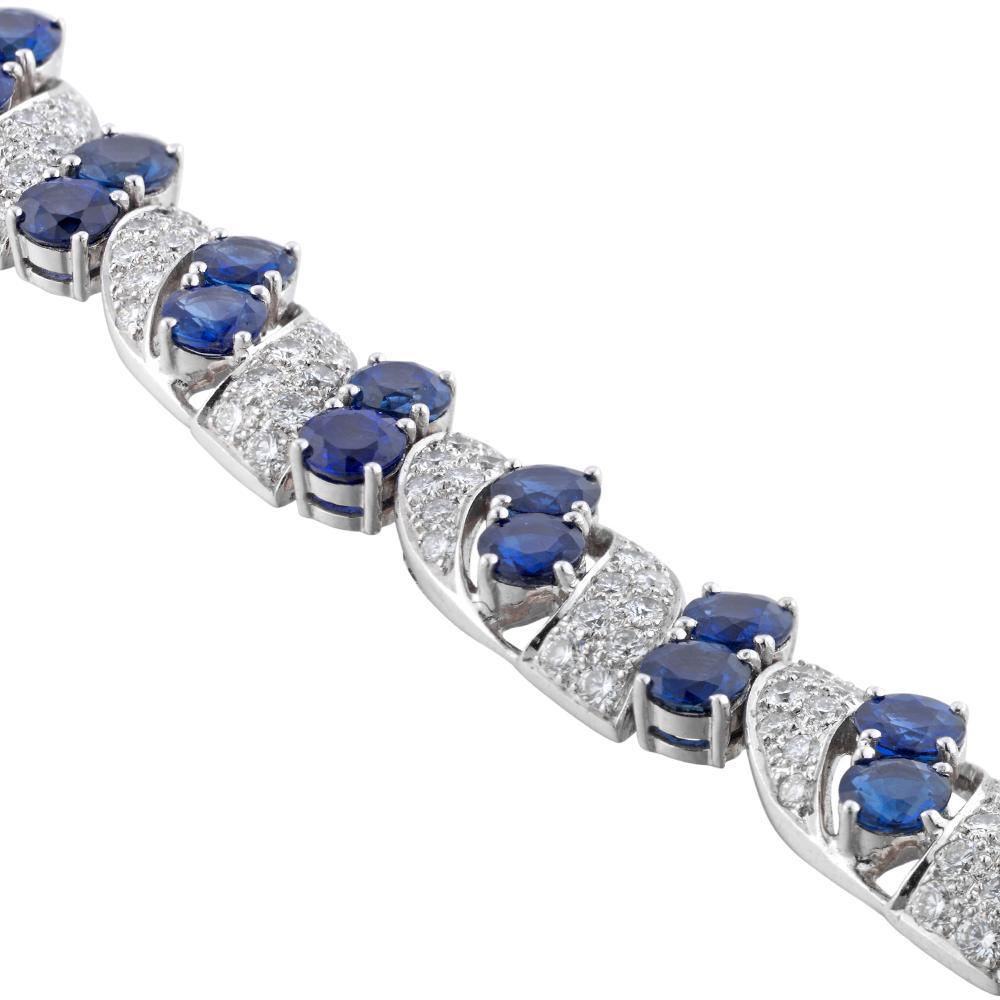 A vintage sapphire and diamond bracelet, consisting of eight links each centrally set with a pair of round faceted sapphires between two diamond-set scrolls, connected by eight pairs of round faceted sapphires, the sapphires estimated to weigh 12