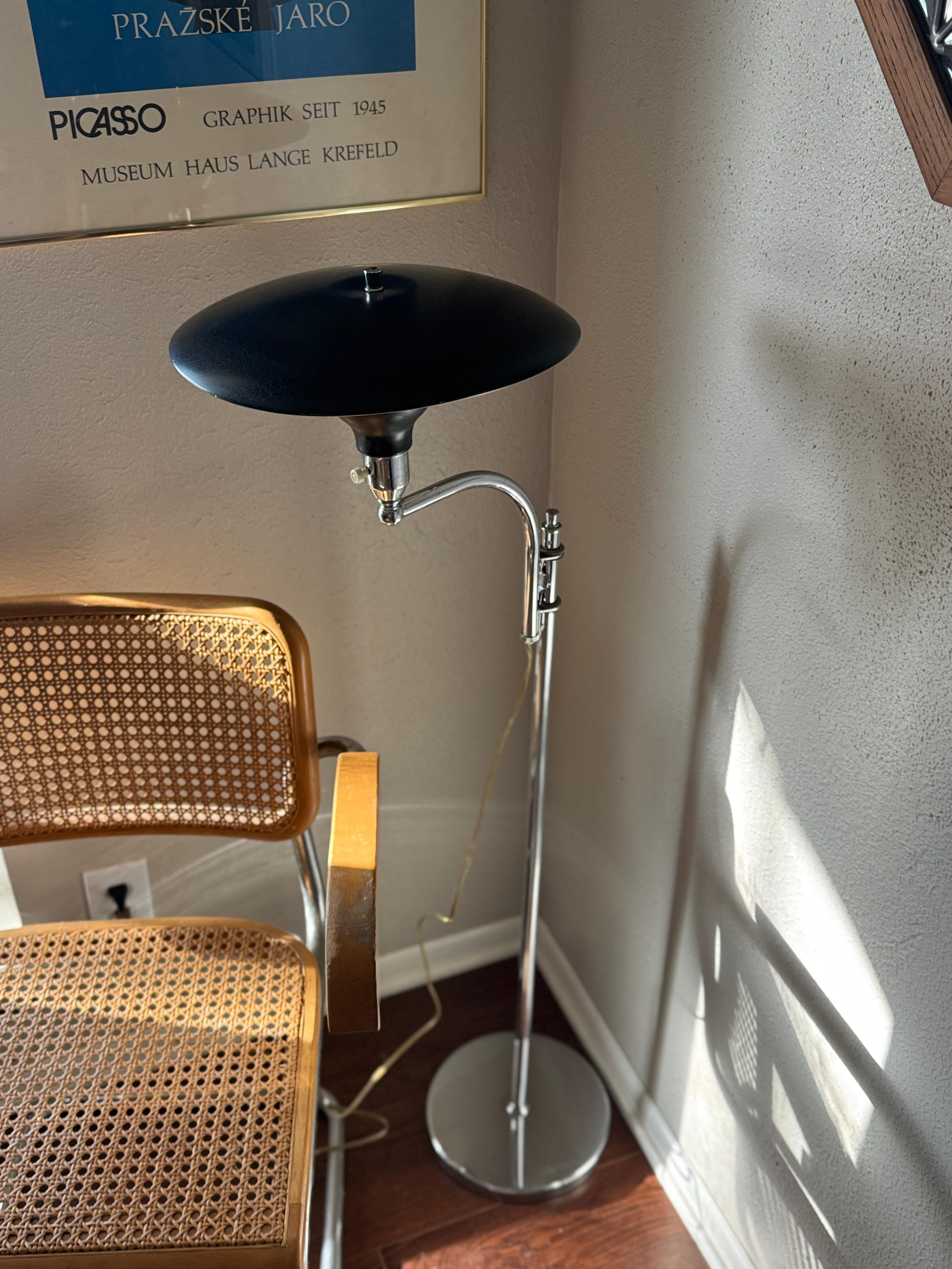 A vintage “Sight Light” adjustable floor lamp by M.G Wheeler, circa 1950s. This lamp is entirely adjustable, with the shade swinging around in any direction and easily brought up or down on the shaft. It has a sophisticated black and chrome finish,