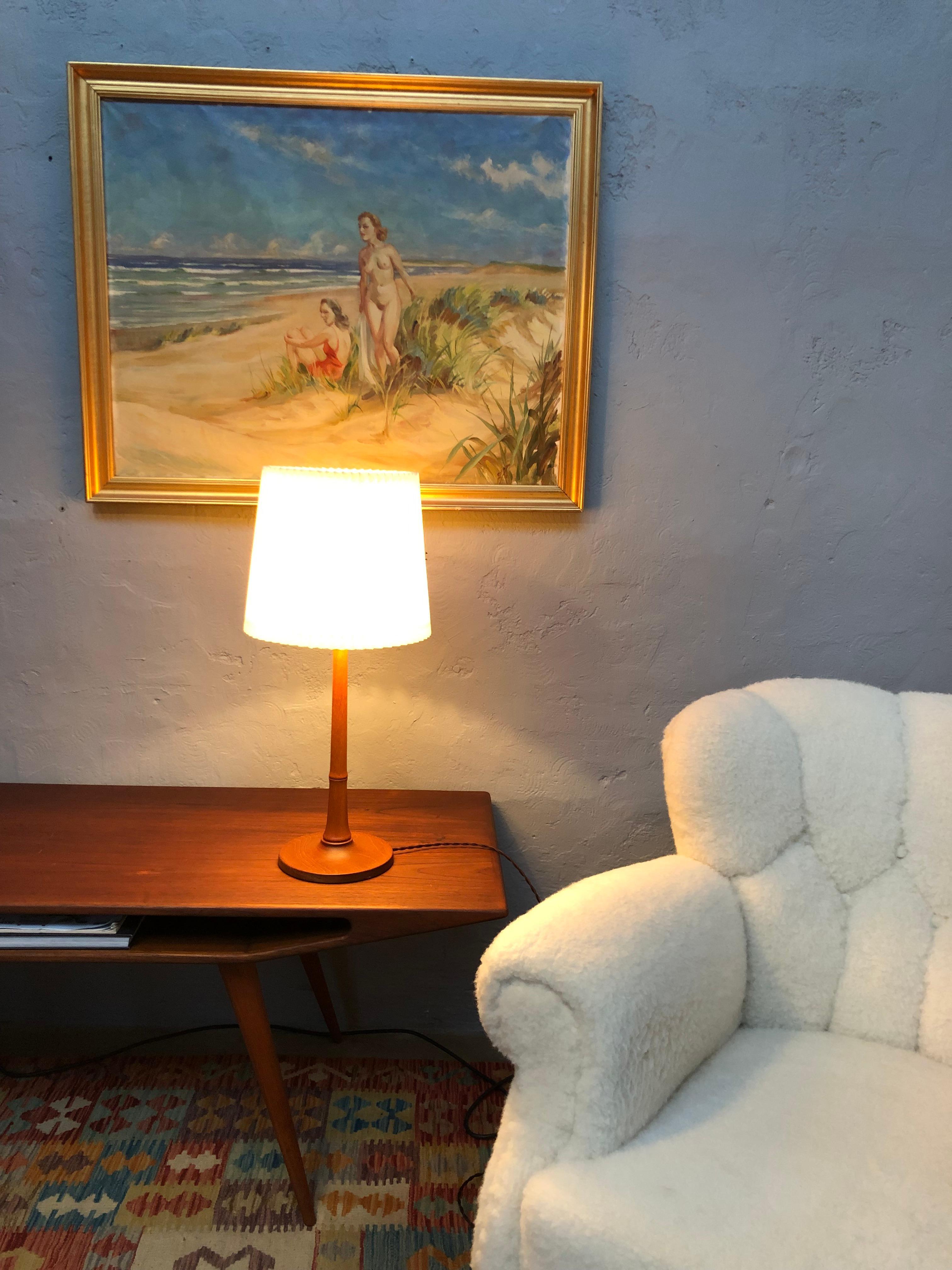 A vintage table lamp in solid teak designed by Esben Klint for Le Klint from the 1940s. 
Turned oak wood and in great vintage condition with all the original parts. 
Rewired with brown cloth flex and can be fitted with an EU, US or UK plug. 
This is