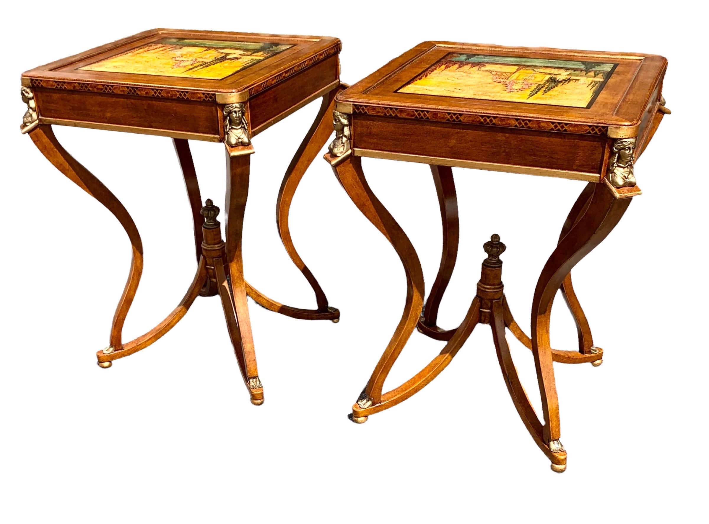 An unusual, delicate and rare set of two mid century Italian side tables with outstanding hand painted scenes of Italian gardens with flowing fountains on each of the table tops. The top four corners of each table having ormolu busts of women, the