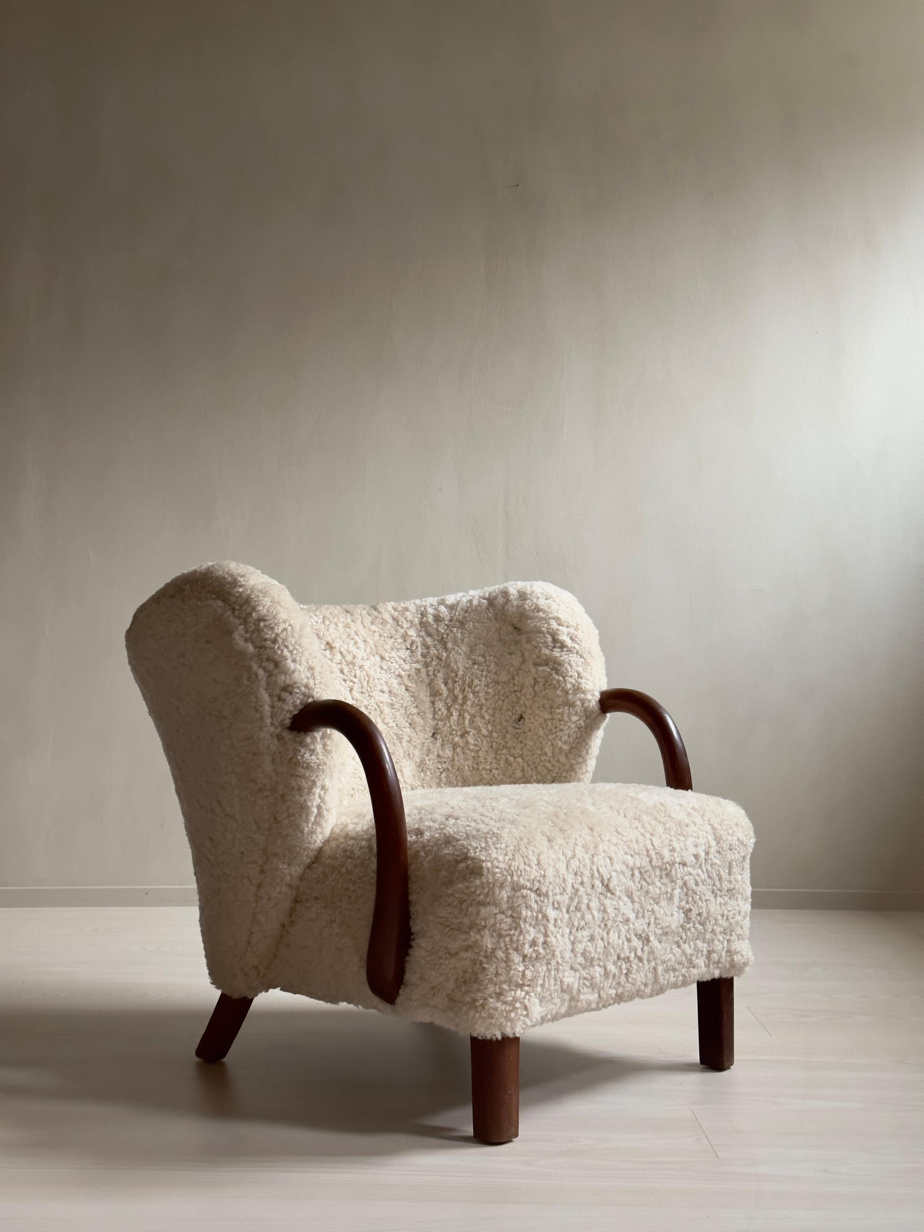 A rare armchair by Viggo Boesen, model 107 for Slagelse Møbelværk. Produced in Denmark in the 1940s. Arms and legs of dark stained oak, newly reupholstered in premium shearling. 


