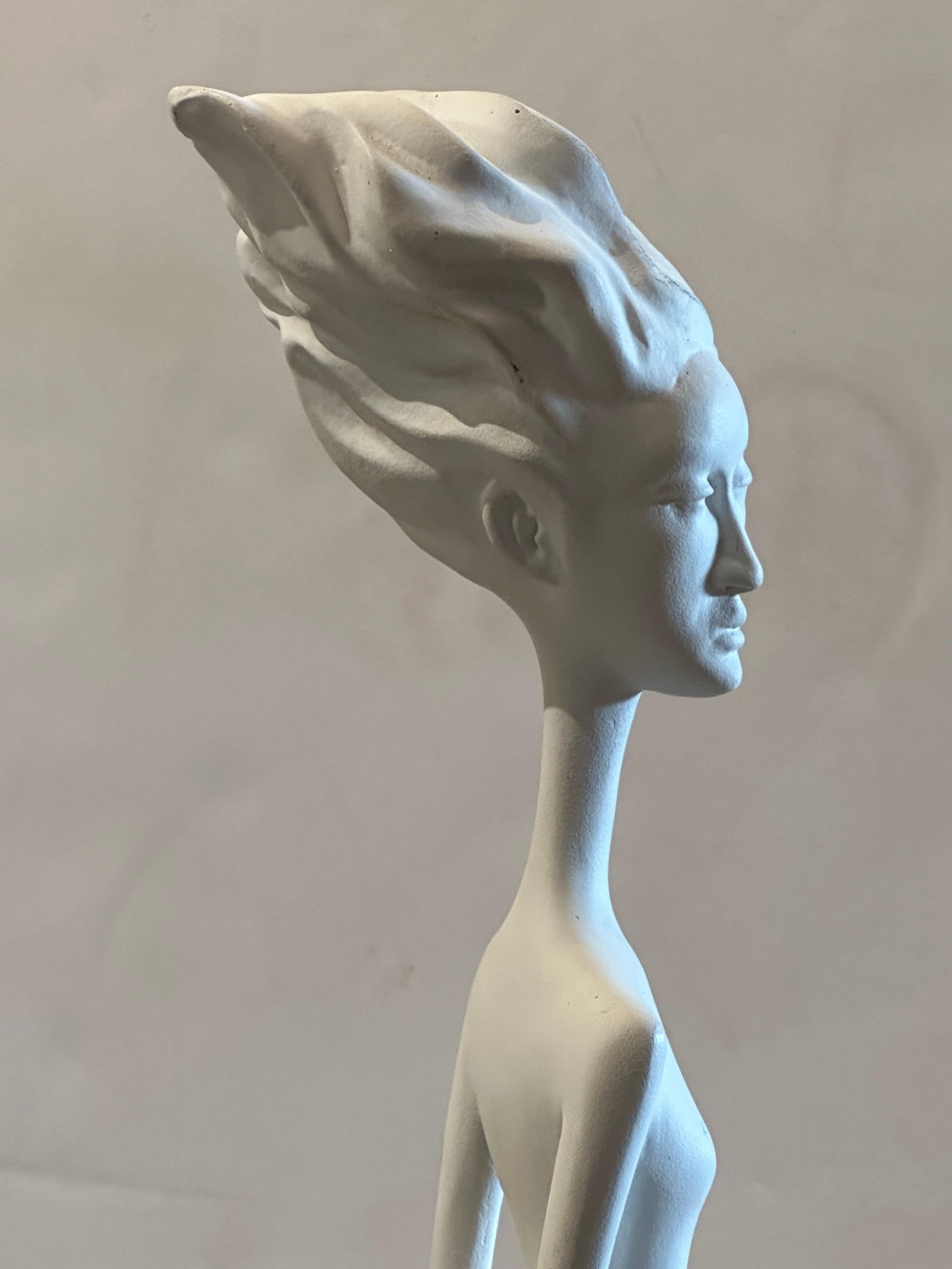This captivating folk art sculpture crafted in white plaster creatively explores the mysterious Arcturian aliens' world. The figure of the alien girl, with her elongated skull, extended neck, slim jaw, and filiform body, and the subtle tension in