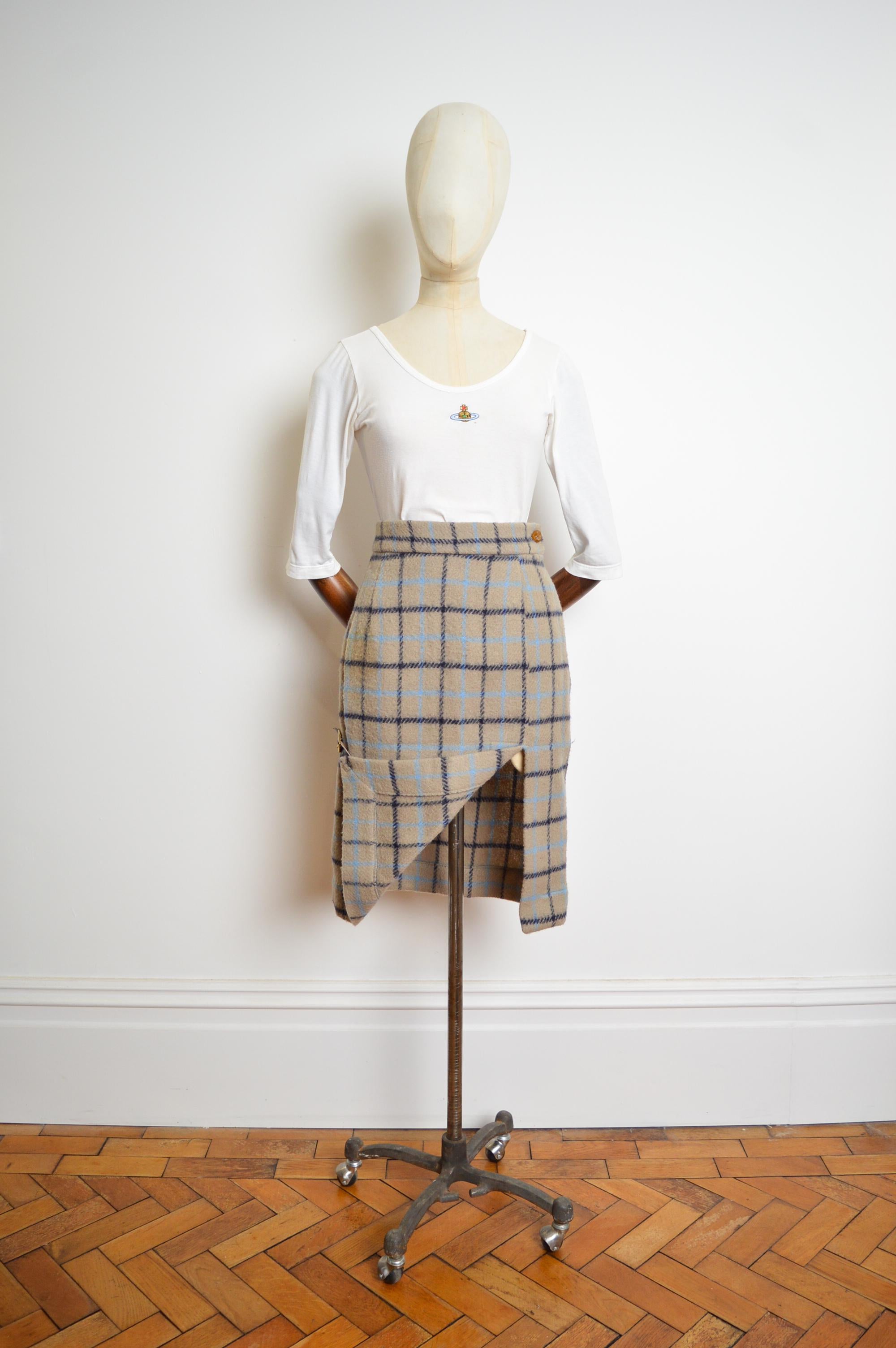 A rare and wonderful piece from the autumn/winter 1988-1989 'Time Machine' collection by Vivienne Westwood.

This duck egg blue plaid skirt is crafted from a checked wool cloth offering a high waisted silhouette and unusual decorative buckled tail