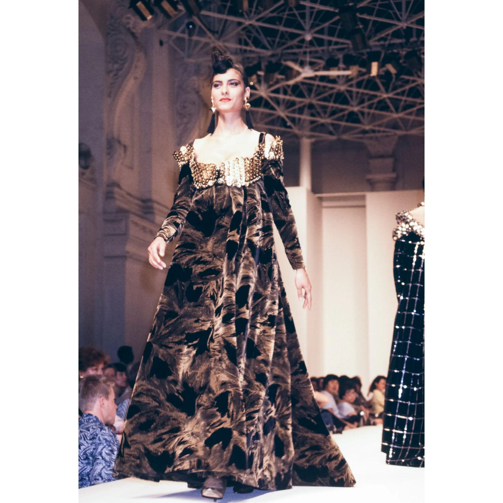A/W 1988 Paco Rabanne Haute Couture gown with floral chainmail bust and black and gold feather patterned velvet sleeves. Features long gold cube drop chain with black tassel at back. Sleeves and chainmail drape off-shoulder, with thin straps at