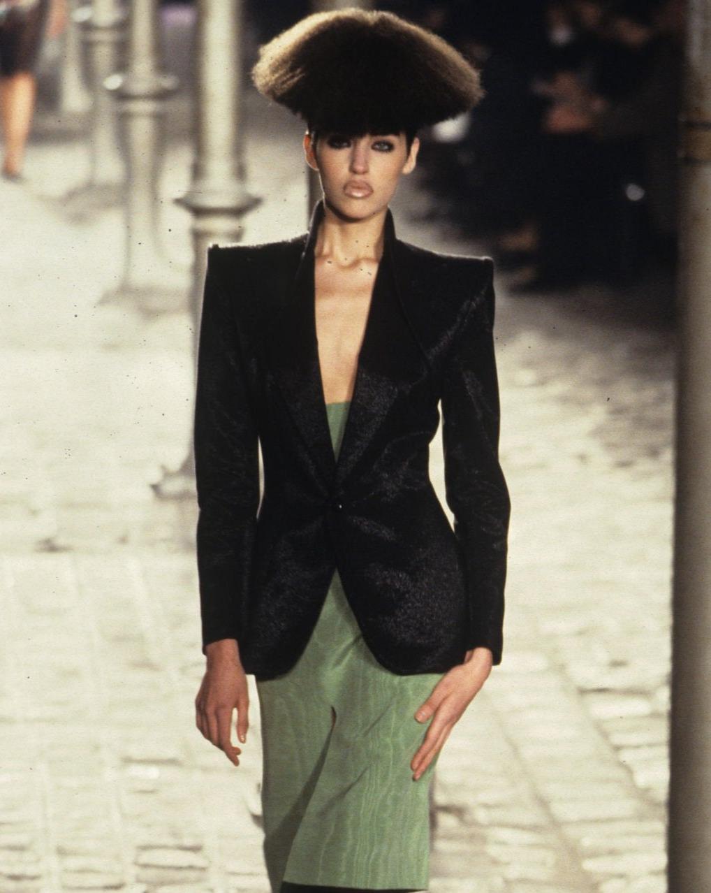 A/W 1997 Givenchy Couture by Alexander McQueen black skirt suit set. Blazer jacket features single button closure, with special interlocking peak lapel construction. Pairs with matching above-knee straight skirt with back zip closure. Both are black