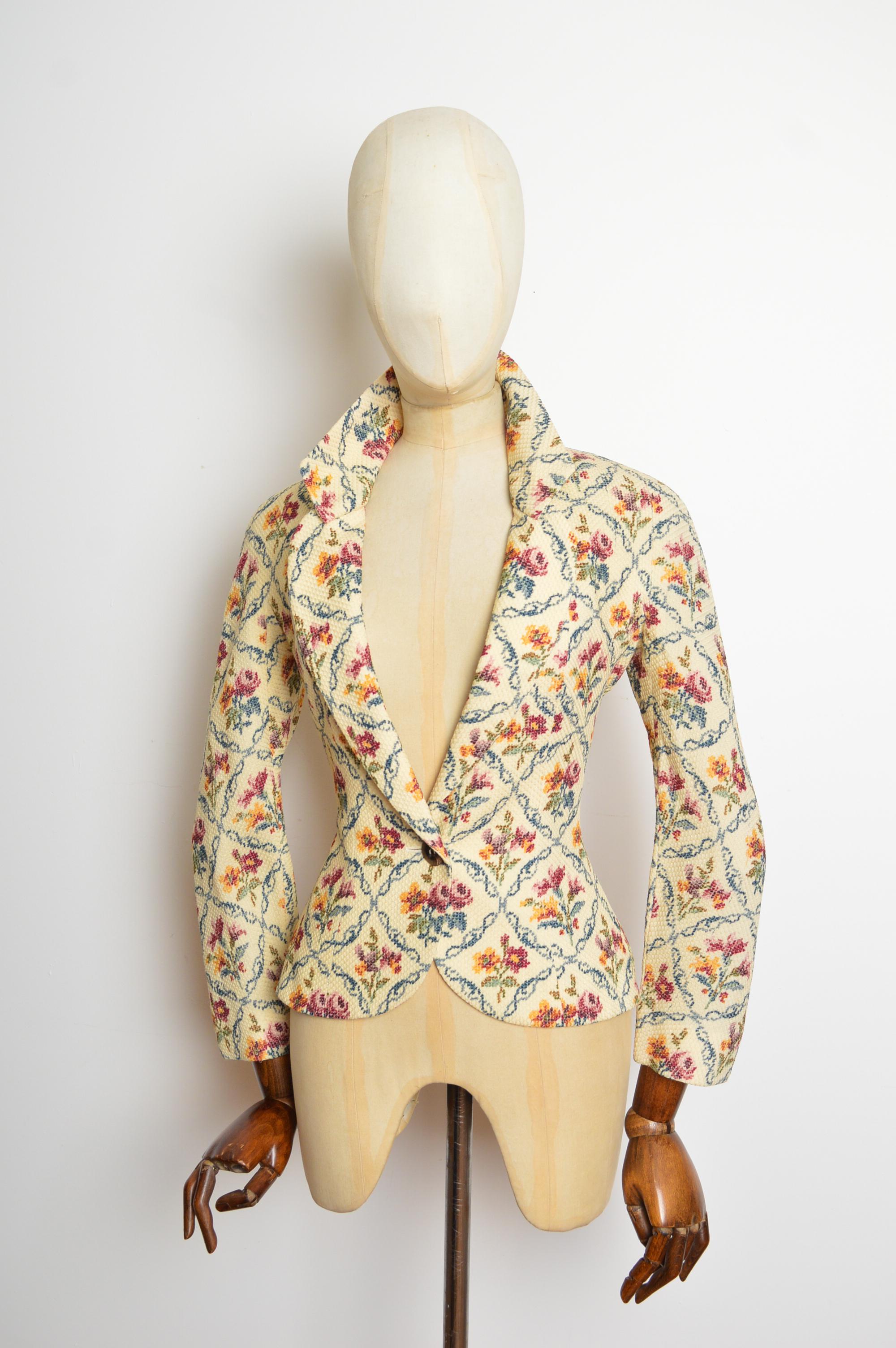 A sublime Autumn / Winter 1999 Christian Dior jacket by John Galliano. Featuring a beautifully decorated floral 'Cross-stitch' patterned exterior, slimline figure hugging silhouette and single button closure. 
Exquisitely tailored, silk lined and