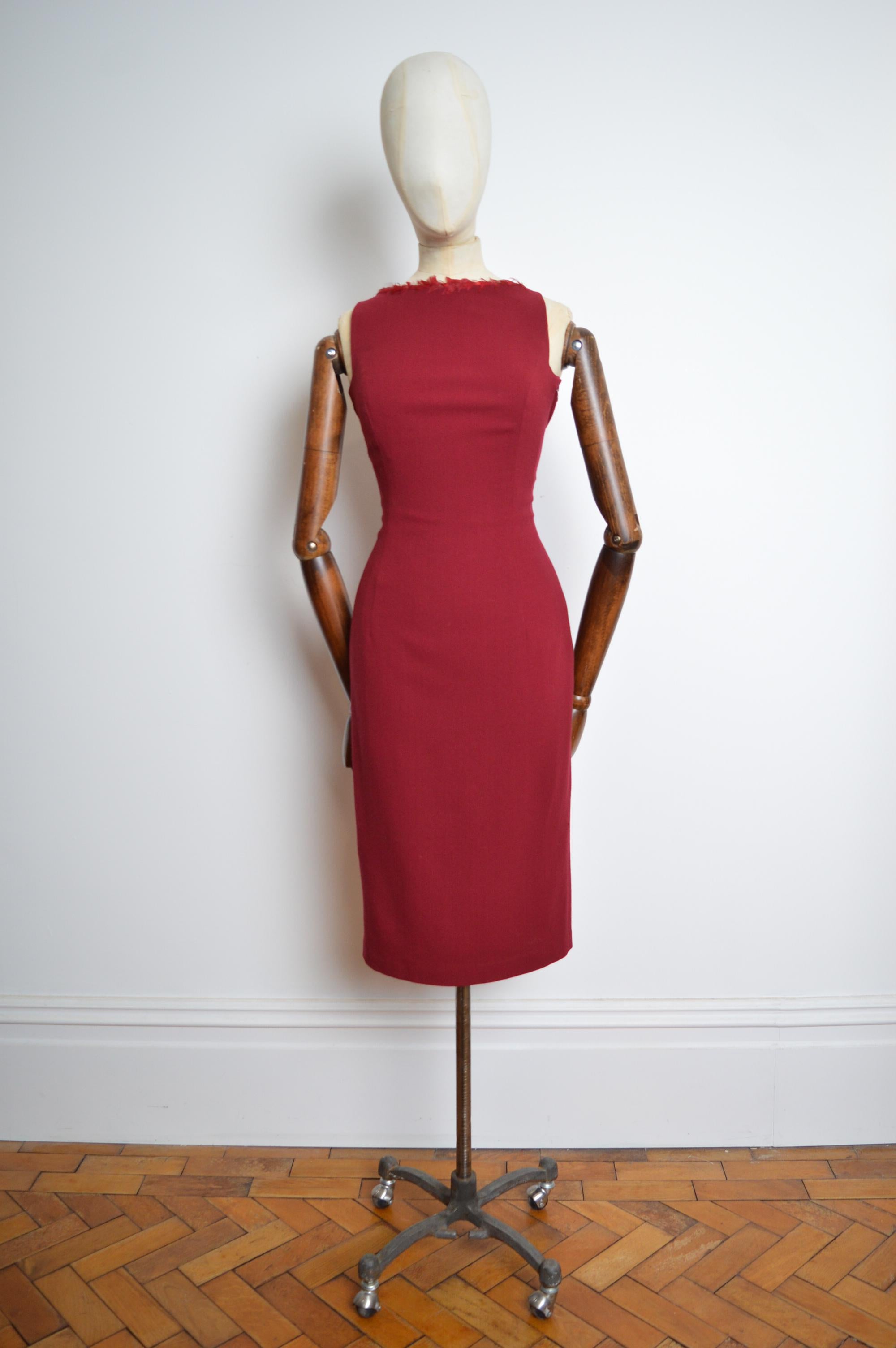 
Espléndido vestido camisero burdeos John Galliano A/W 1999 con detalle de plumas alrededor del cuello y cierre lateral de cremallera oculta. 
De foso a foso; 17