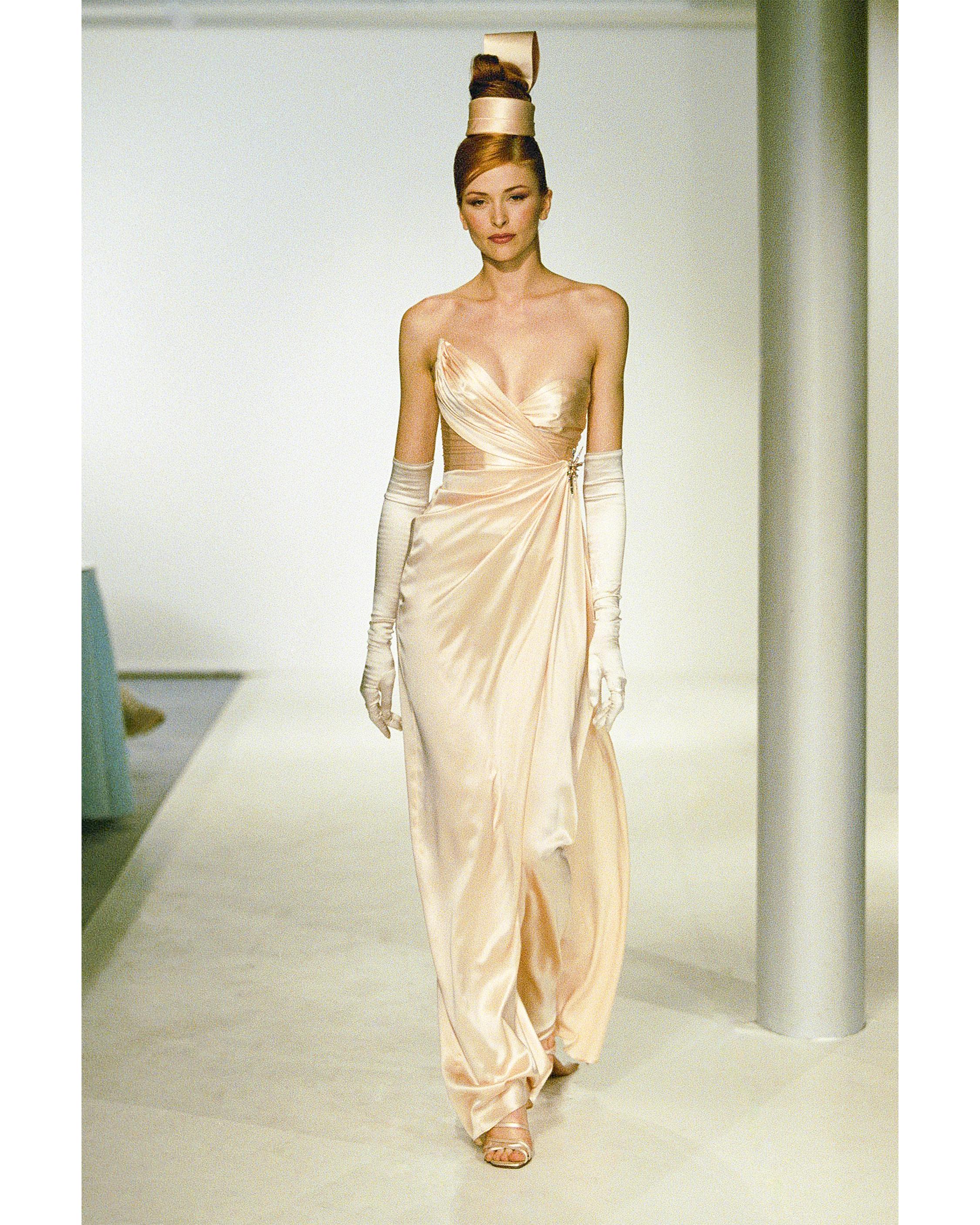 A/W 1999 Thierry Mugler light peach-pink asymmetrical strapless silk drape column gown. Corset at right side reaches higher point than left side, creating asymmetrical silhouette.  Strapless corset gown with built-in boning, featuring sculptural