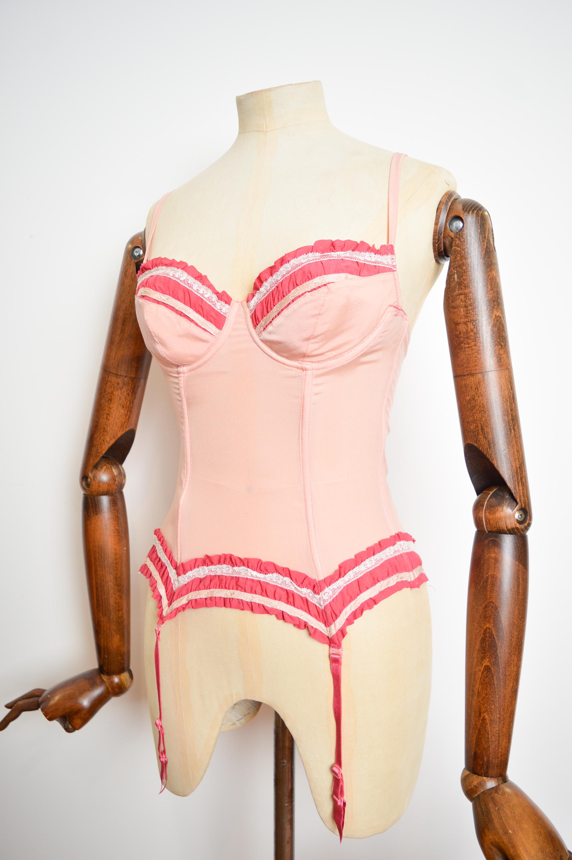 Simply beautiful A/W 2000-2001 silk Lingerie Corset & Panties ensemble by John Galliano.

Crafted from a Light peachy pink coloured silk with a contrasting warmer shade of pink and complementing cream fine lace trim.

Good condition despite some