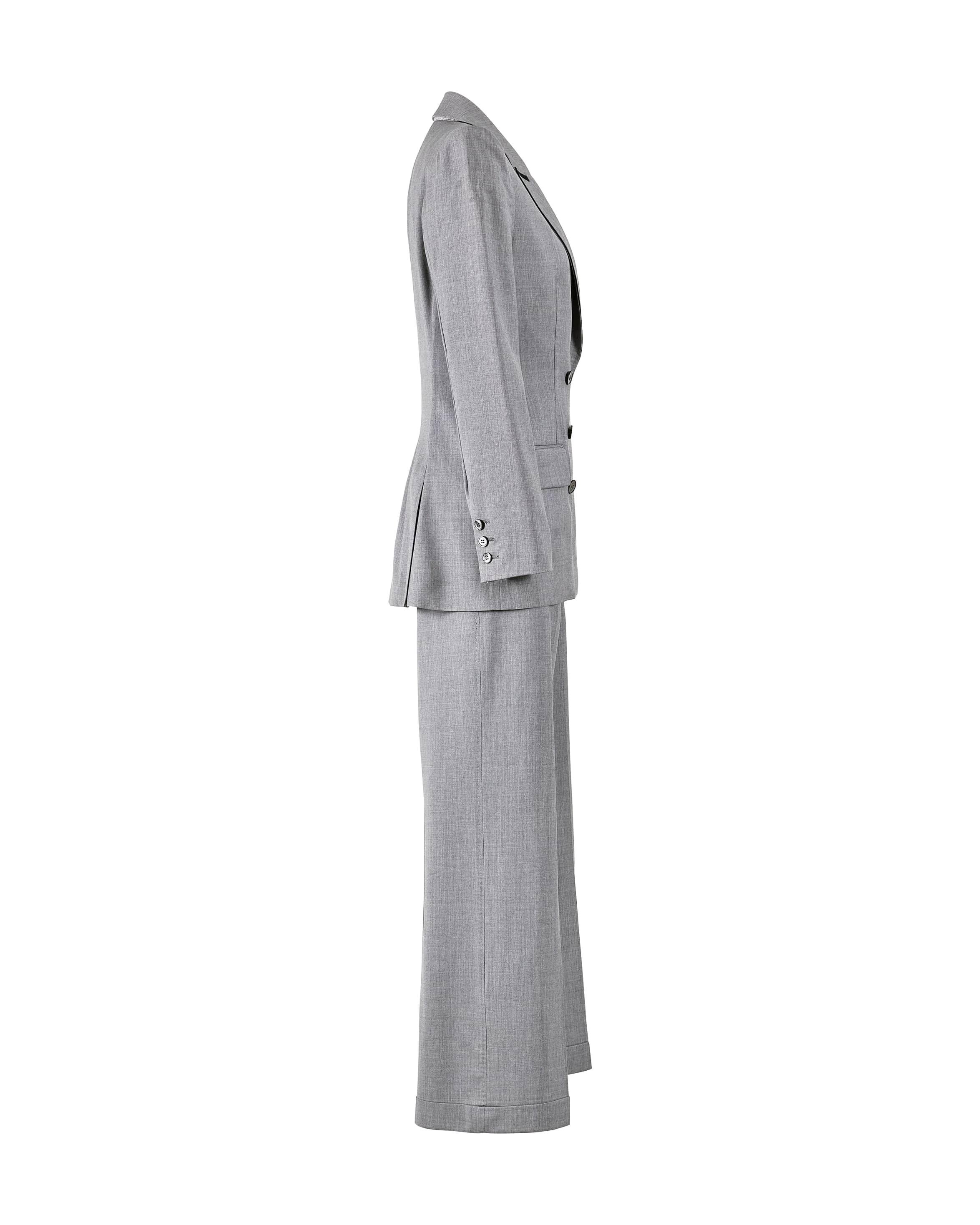 A/W 2003 Alexander McQueen “Scanners Collection” grey 2-piece suit set. Double-breasted jacket with black lining across collar, and mid-sized shoulder pads. Grey mother of pearl buttons. Straight cut mid-rise pants with two front hip pockets and