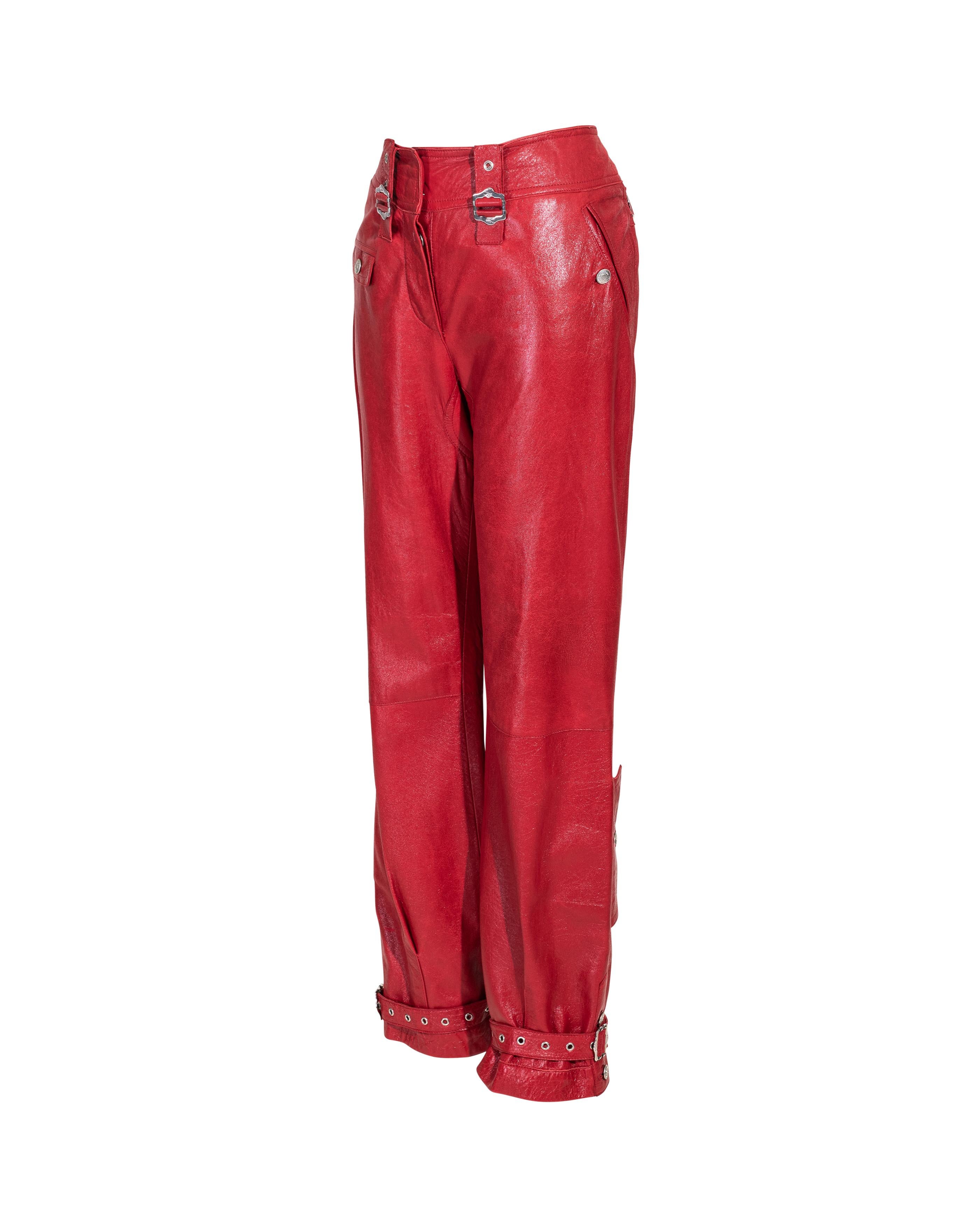 A/W 2003 Christian Dior by Galliano ‘Hard Core’ collection mid to low-rise red leather pants with silver-tone details. Features silver-tone stamped buckle details at waist, small flap stamped pockets and adjustable silver grommet buckle straps