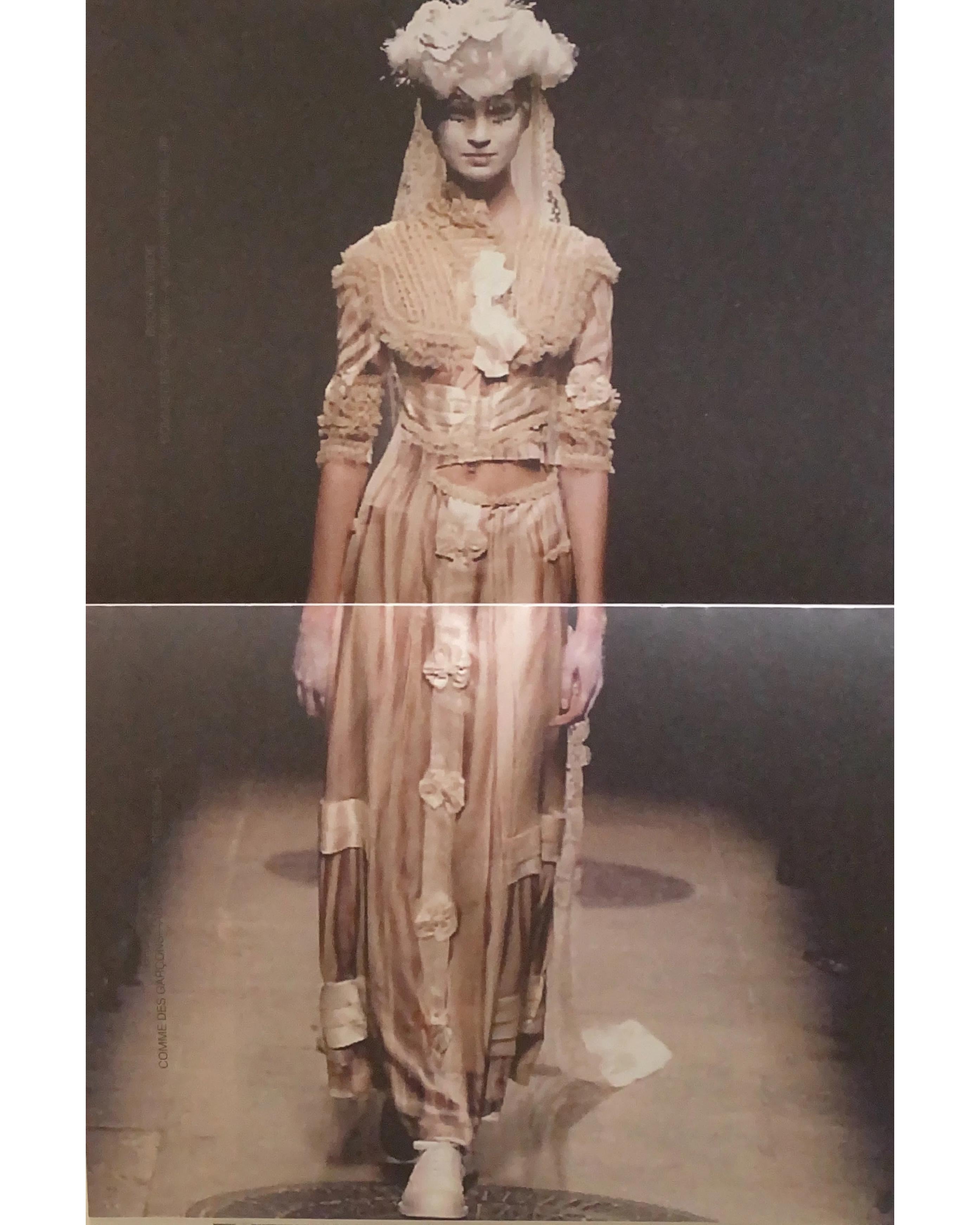 A/W 2005 Comme des Garcons by Rei Kawakubo 'Broken Bride' Collection deconstructed tan gown. Features trompe l'oeil pleating and hem pattern effect throughout. Contrasting neutrals with light cream, tan and brown ruffles and bows at front, back and