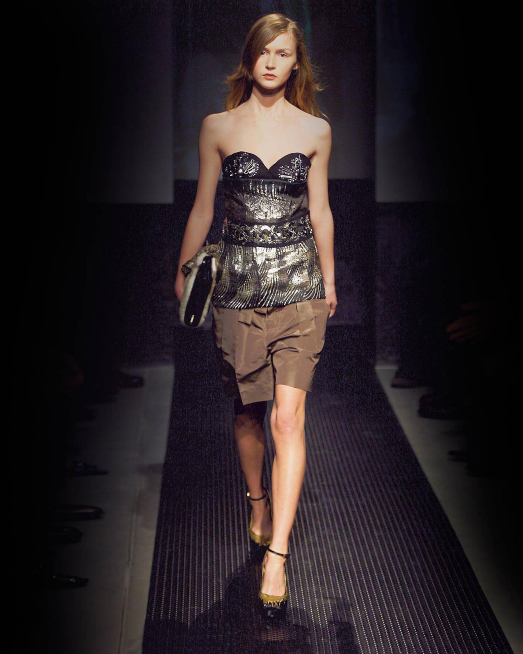 A/W 2006 Prada by Miuccia Prada black bustier with silver embellishments throughout. Upper composed of black felt fabric, and lower composed of semi-sheer mesh. Silver paillette and 'gear' inspired embellishments and 3D circular details at bust.