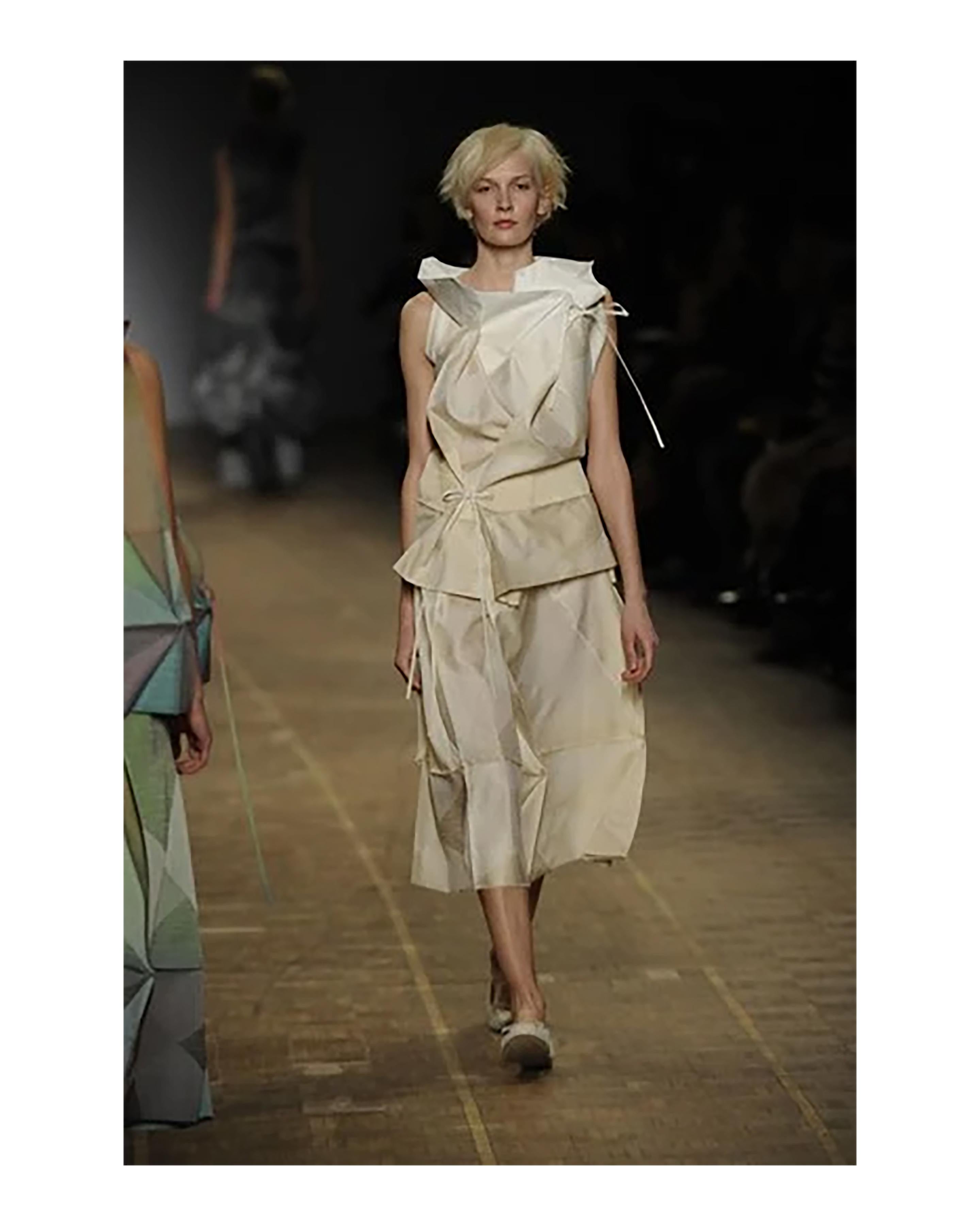A/W 2008 Issey Miyake white and cream geometric sleeveless gown. Layered cowl neck dress with adjustable ties at chest and waist allowing for a variety of styling and sizing opportunities. Features triangular geometric paneling throughout,