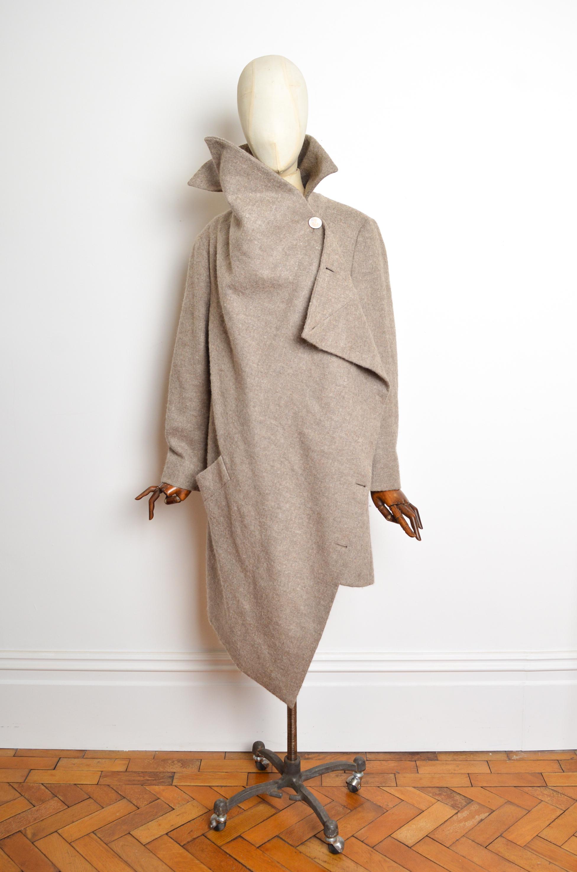Superbo cappotto asimmetrico Wonky di Vivienne Westwood dell'autunno/inverno 2015 nella tonalità crema Biscuit, caratterizzato da maniche lunghe, taglio asimmetrico drappeggiato (che può essere adattato per creare un'ampia varietà di splendide