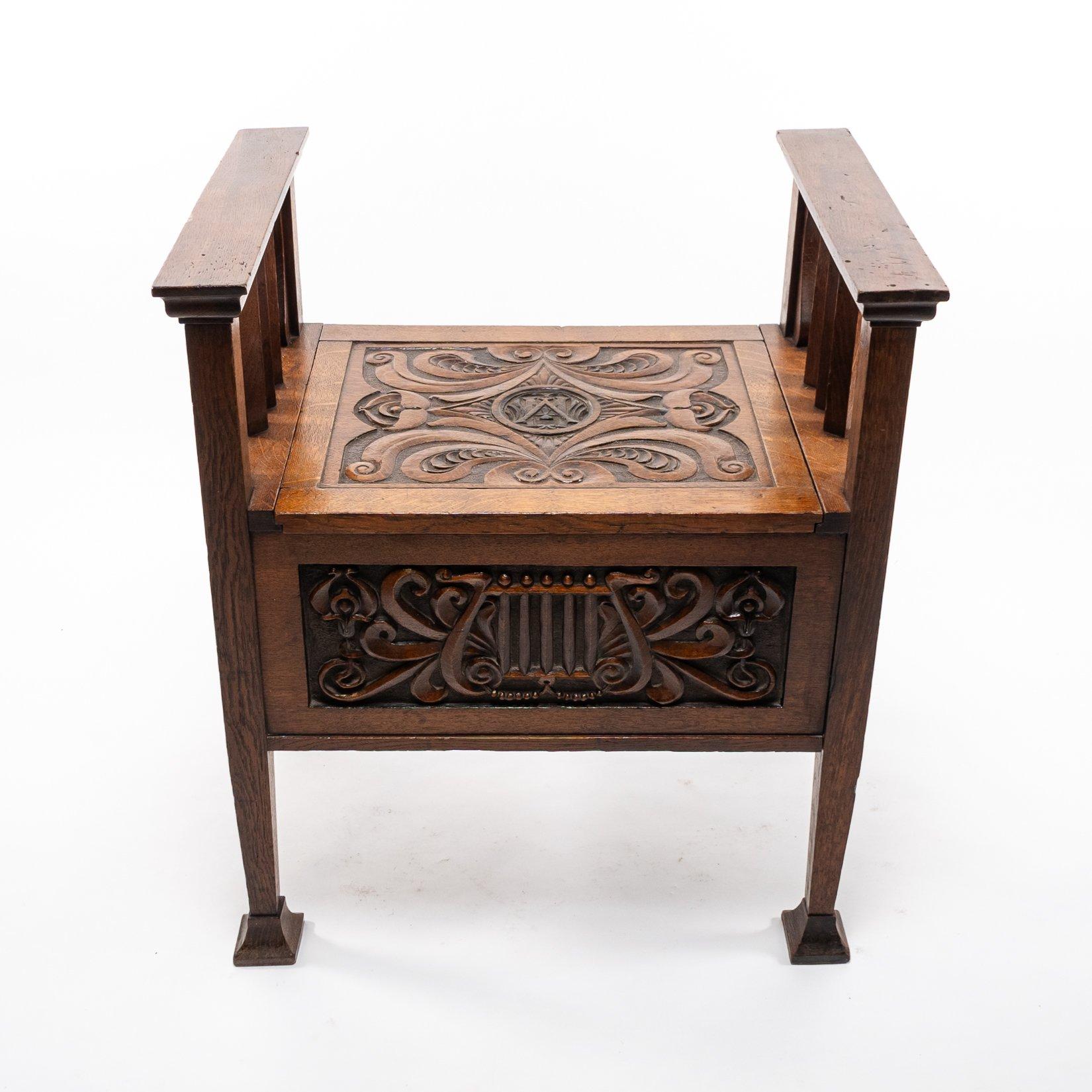 A. W. Simpson zugeschrieben, Arts and Crafts Klavierhocker aus Eiche
Klavierhocker aus Eichenholz im Arts-and-Crafts-Stil mit geschnitztem Blumendekor auf dem hochklappbaren Sitz und einer großen Ablagefläche im Inneren. Die unteren Seiten sind mit