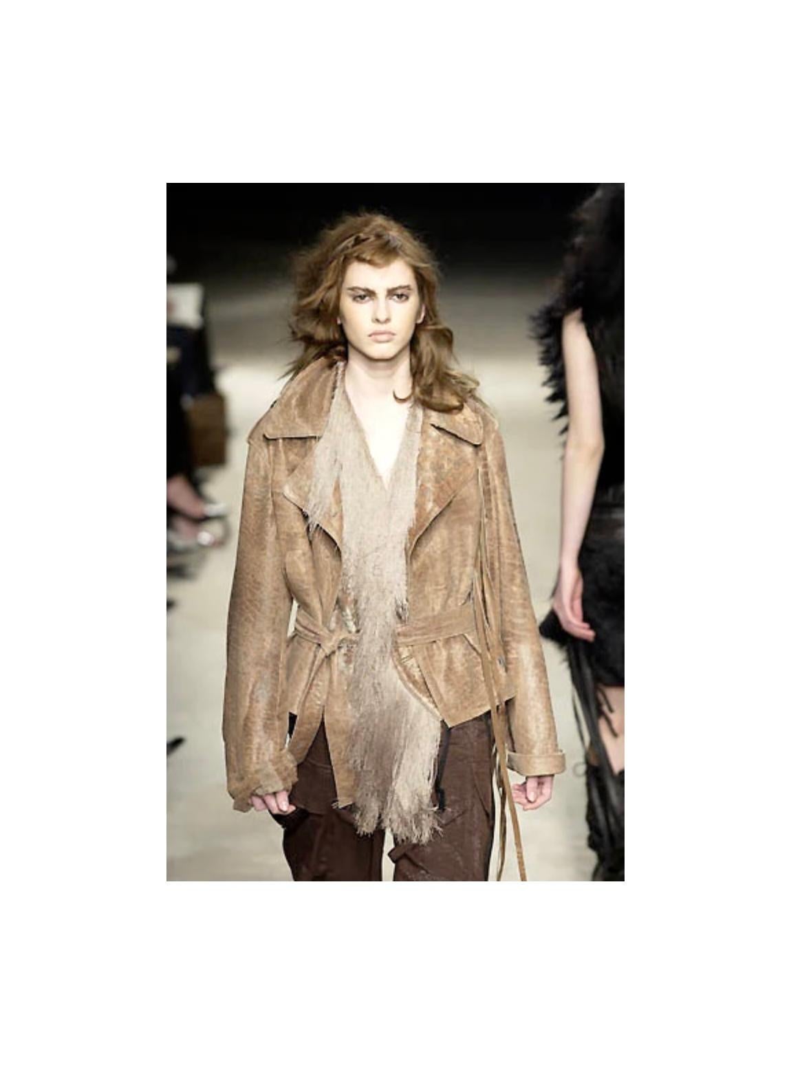 Giacca a tracolla in pelle Ann Demeulemeester A/I 2002. Realizzata in morbida pelle beige leggermente invecchiata, presenta una struttura a portafoglio asimmetrica e spalline estese che scendono dal pannello frontale. Progettato con risvolti