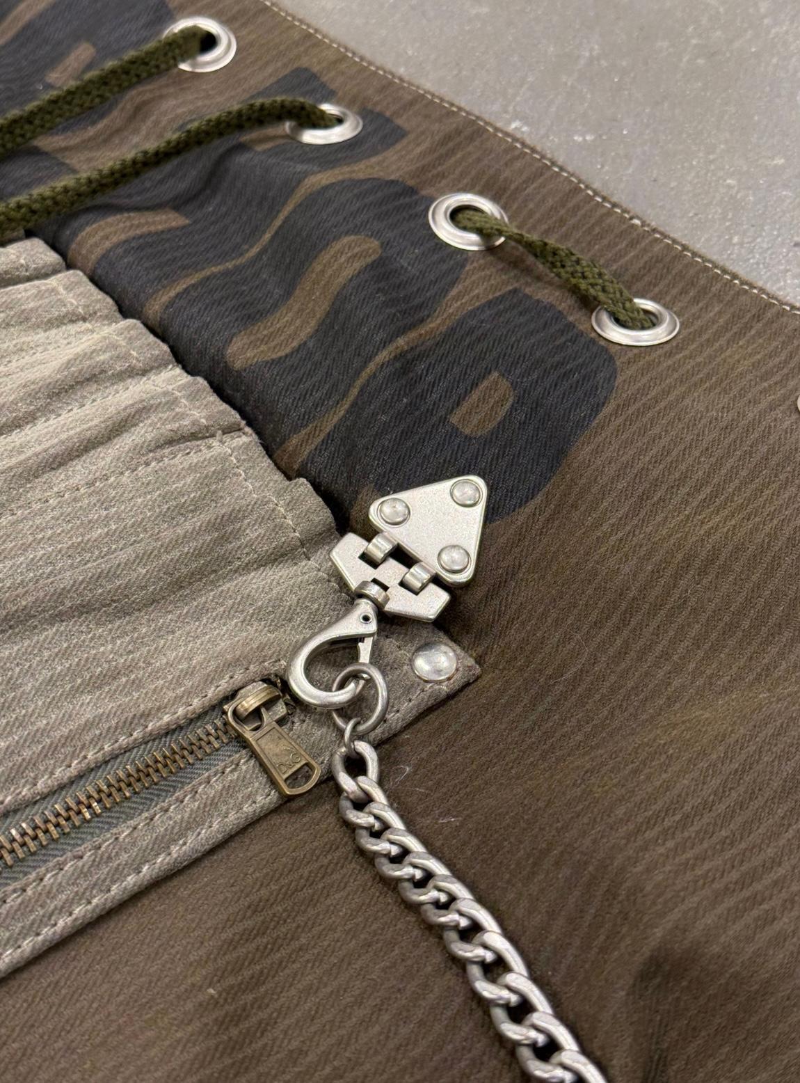 Questa borsa a tracolla Dolce & Gabbana del 2003 mostra l'estetica sperimentale e di utilità del marchio dei primi anni 2000. Realizzato in tessuto color oliva intenso con una sottile texture gessata, presenta una silhouette audace e oversize