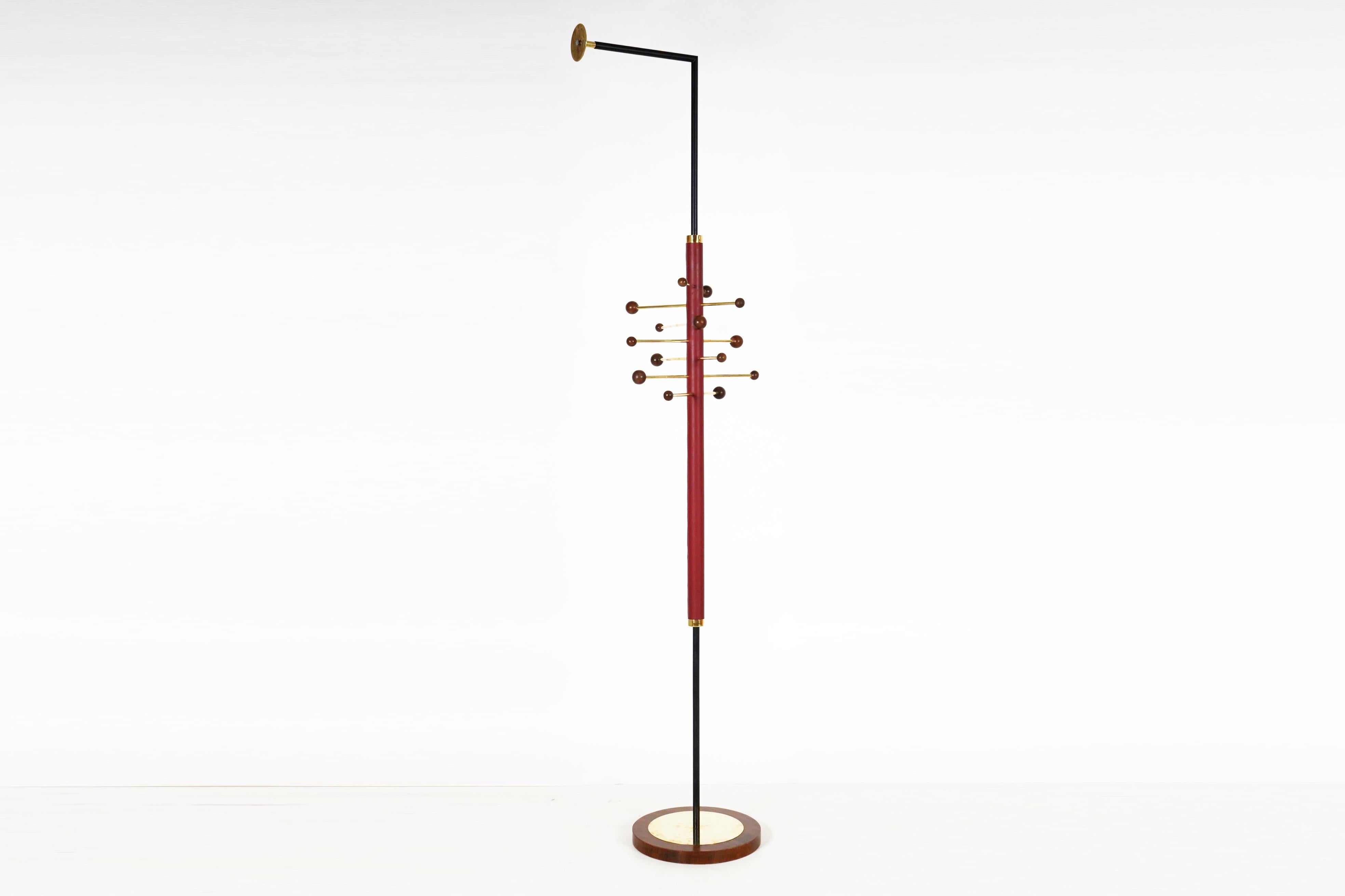 Ce porte-manteau unique se fixe au mur pour une plus grande rigidité. Le tube en laiton poli du poteau central complète la richesse et la chaleur des solides et des placages en noyer. Le bois de noyer a été poli à la française pour obtenir un