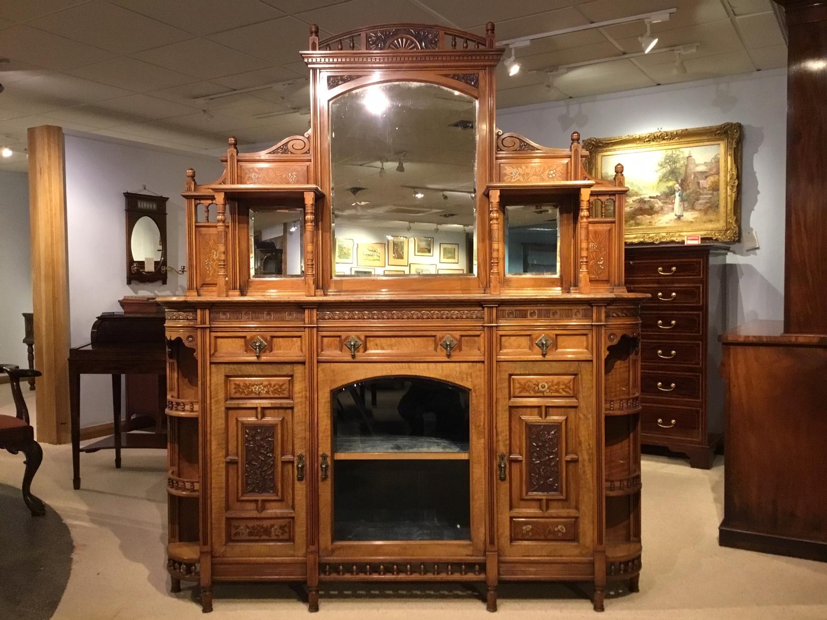 A stunning quality walnut Aesthetic Period chiffonier by Ogdens of Manchester. The upper section with three bevelled mirrors within a finely carved back, very much in the manner of Bruce Talbert who designed furniture like this for Gillows and Lambs
