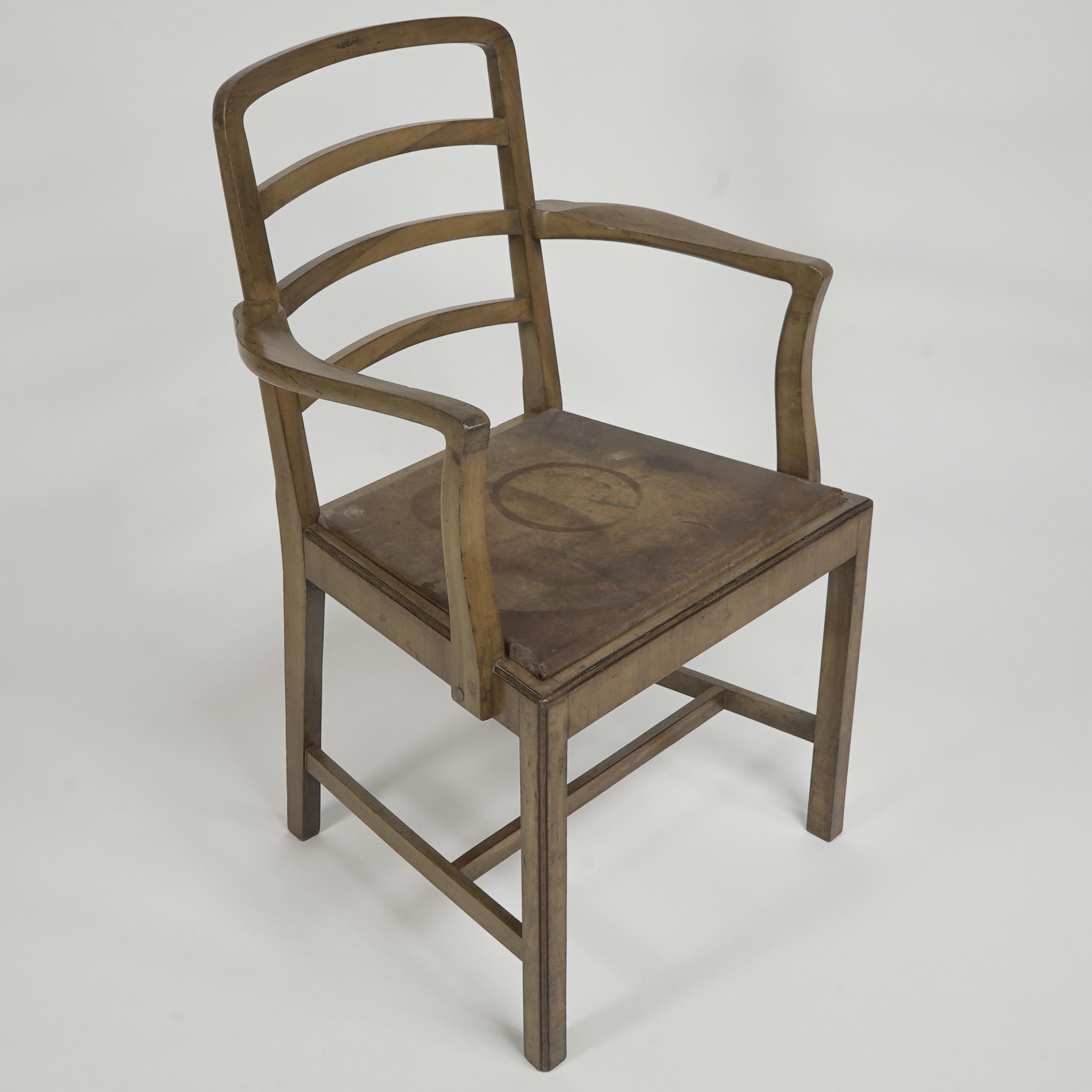 Heals attributed. A Walnut desk chair or armchair with a rounded top and ladder back, sculptured curvaceous arms, the four legs united by an 'H' stretcher.
